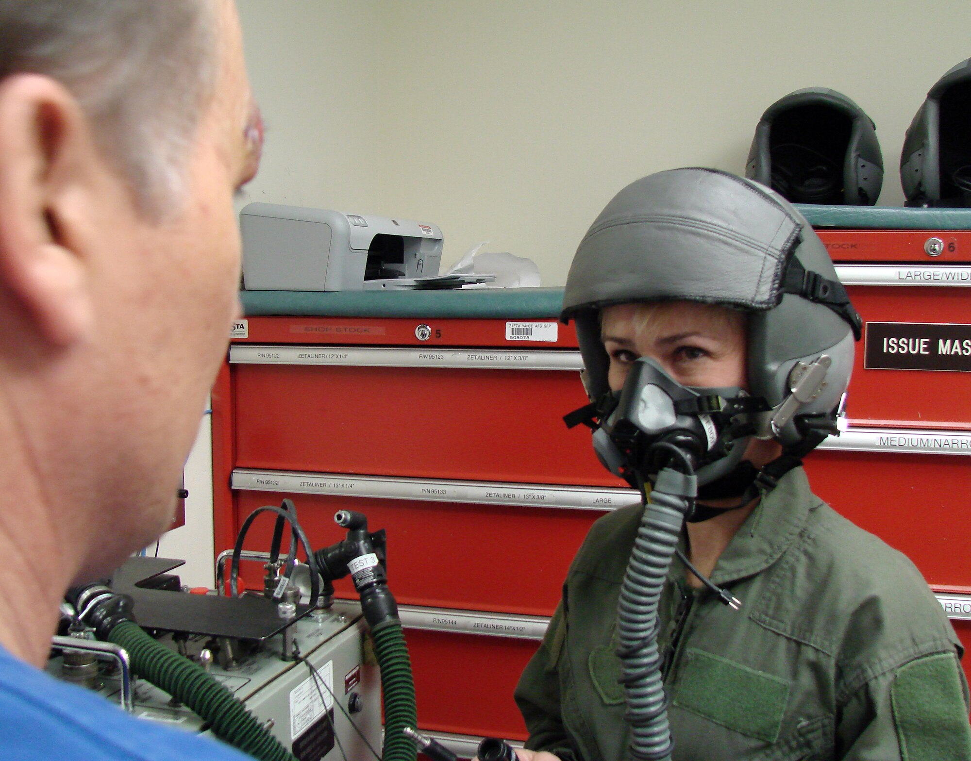 Sharon Trojan, the 71st Mission Support Group honorary commander, gets fitted for an oxygen mask in preparation for a T-6 orientation flight with the 33rd Flying Training Squadron, Feb. 3, at Vance AFB. Dennis Burris, left, a life support specialist, makes sure the mask seals properly. Ms. Trojan, a member of the Northern Oklahoma College/Northwestern Oklahoma State University advisory board and local certified public accountant, has spent the past year learning about the Air Force and Vance AFB while paired with Col. Jennifer Graham, the 71st MSG commander. (U.S. Air Force photo by Joe B. Wiles)