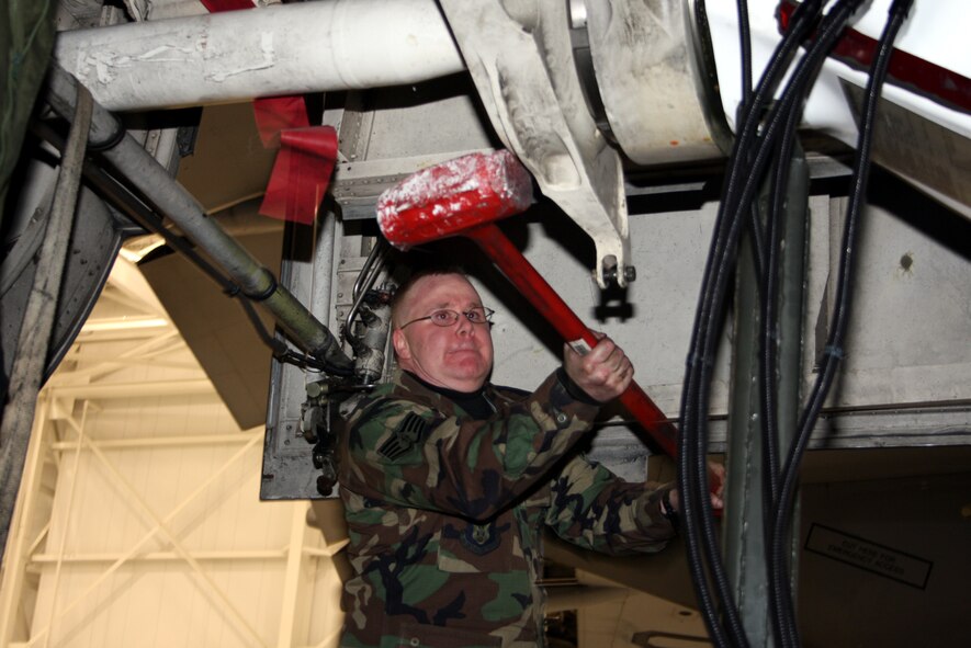 WRIGHT-PATTERSON AFB, Ohio - Master Sgt. Stan Evans, 445th Maintenance Squadron, uses all his muscle to get the strut aligned in place on a C-5A Galaxy. (Air Force photo/Senior Airman Ken LaRock)