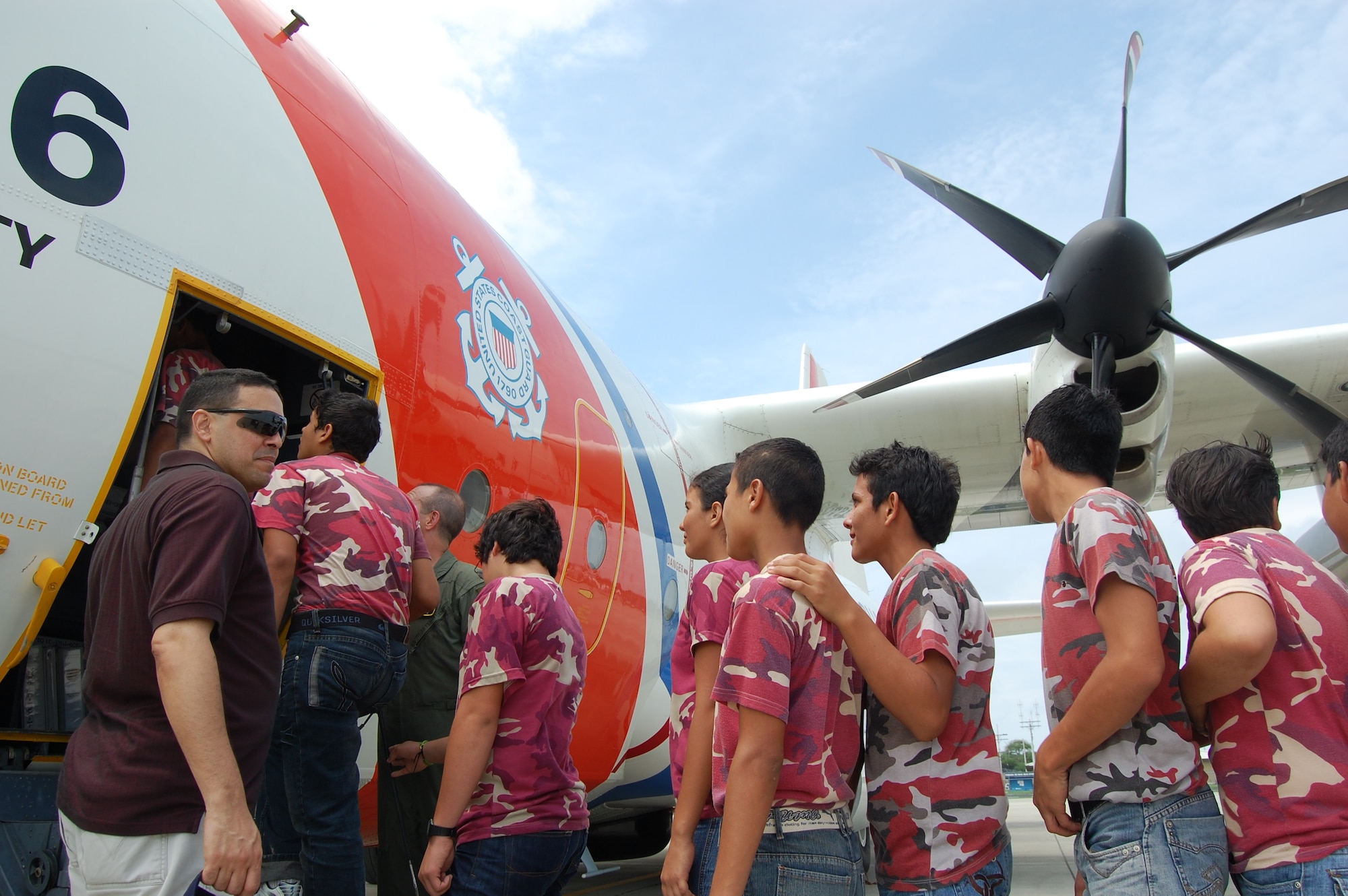 Capt. Gabriel Rios (far left), 478th Expeditionary Operations Squadron chaplain, escorts firefighters and firekids from Colon, Ecuador to a U.S. Coast Guard C-130J static display here Jan. 31.  FOL Manta personnel provided hands-on medical and fire response training to a group of 40 firefighters and firekids from Colon, Ecuador. The Coast Guard aircraft is deployed to FOL Manta in support of counterdrug operations in the eastern Pacific. (U.S. Air Force photo by 1st Lt. Beth Woodward)