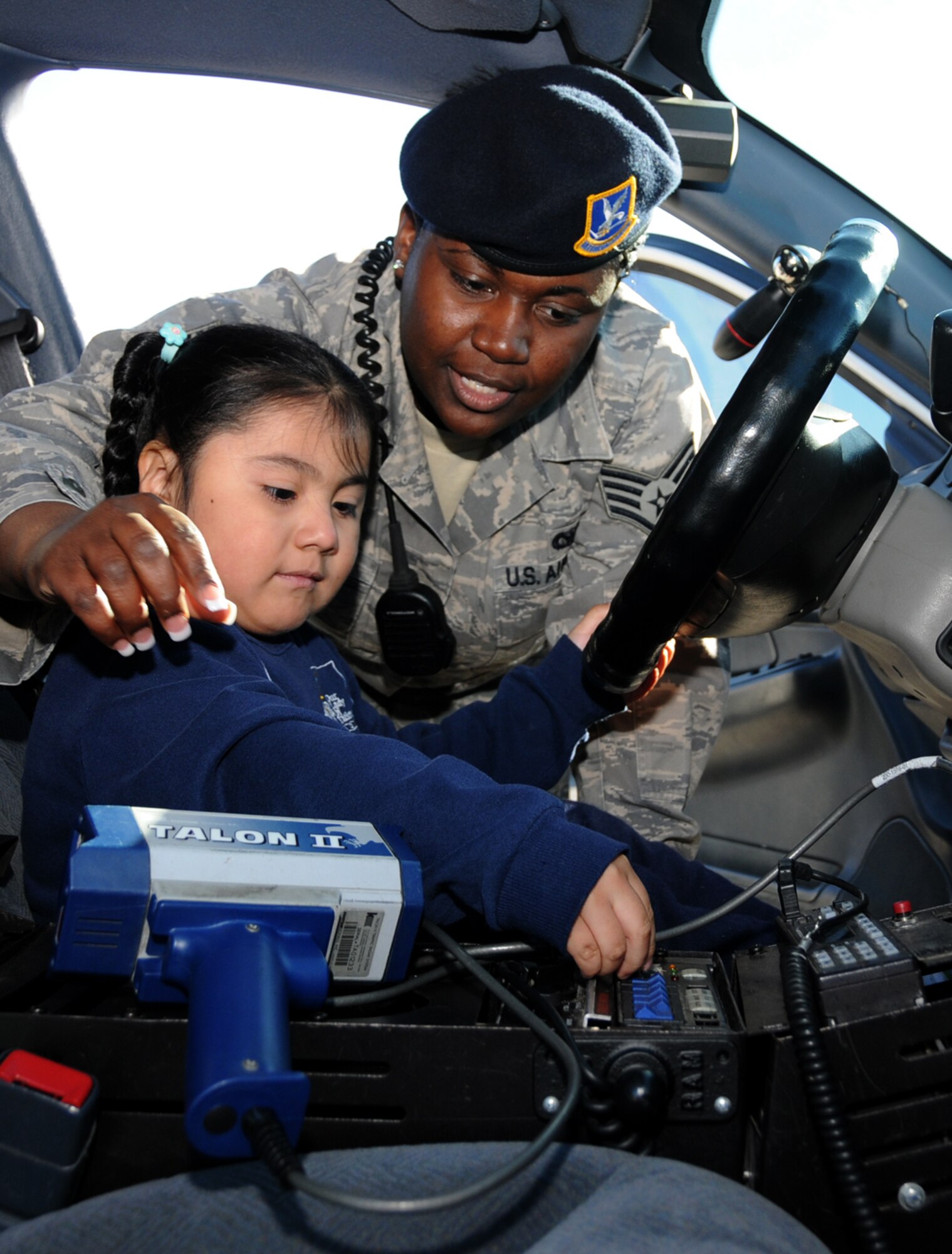 Four-year-old Esmeralda Zamora-Muñoz learns how to turn on the siren of an 81st Security Forces Squadron patrol car from Staff Sgt. Keishonda Signater during Friday’s Transportation Day at Our Lady of Fatima Elementary School in Biloxi.  Esmeralda’s parents are Rodrigo Zamora and Juana Muñoz-Zecua.  Students were introduced to different types of transportation, such as public safety units and construction vehicles.  (U.S. Air Force photo by Kemberly Groue)