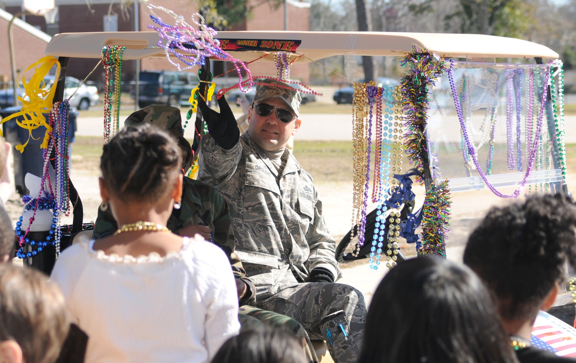 Chief Master Sgt. Damian Orslene, 81st Force Support Squadron superintendent,  throws beads to students at a Mardi Gras parade at Gorenflo Elementary School in Biloxi last year.  (U.S. Air Force photo by Kemberly Groue)