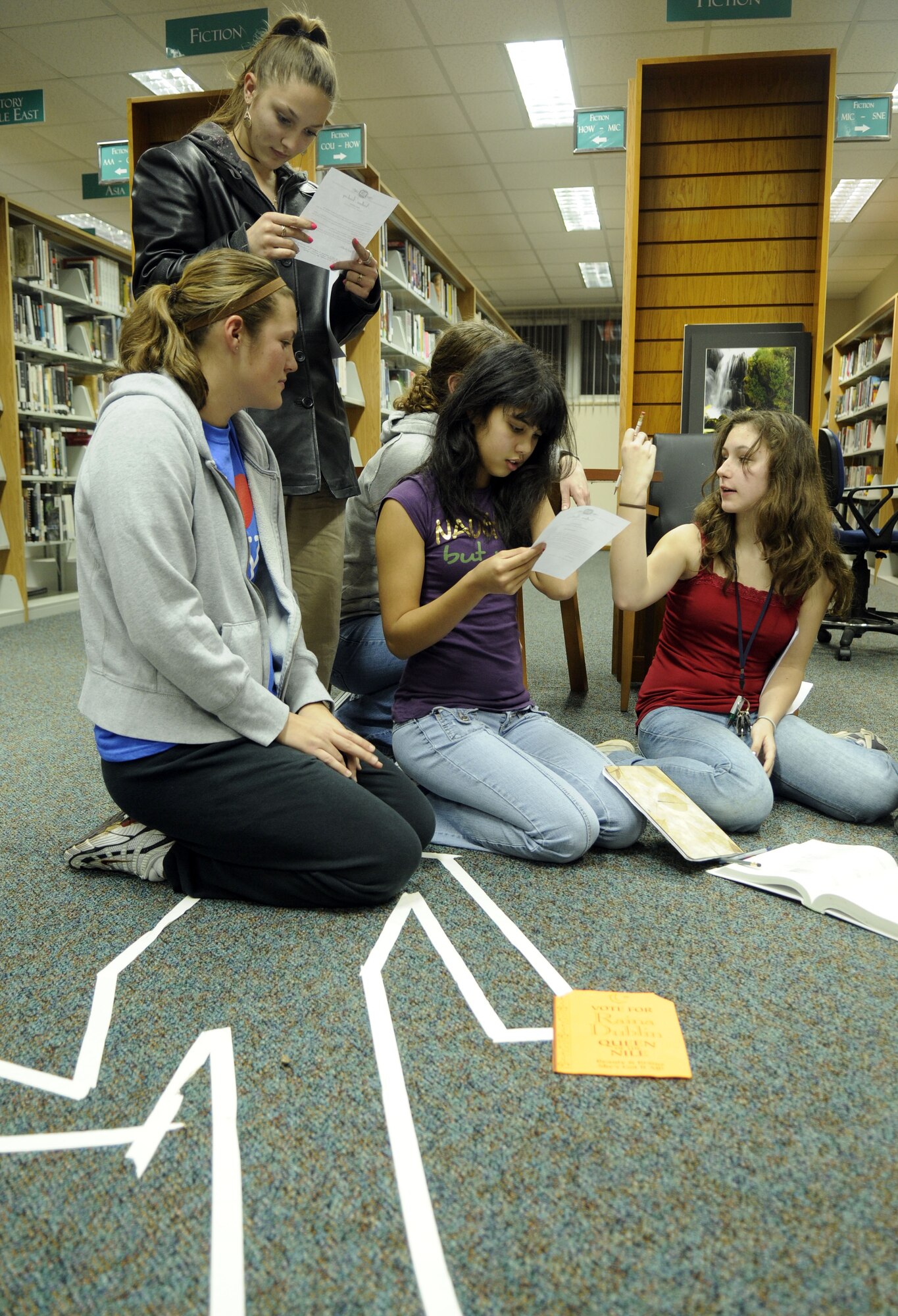 Senior Airman Nikki Brisco, 39th Security Forces Squadron and Club Beyond Volunteer, helps Incirlik Unit School students figure out clues to “The Pharaoh’s Curse” at the library’s Mystery Night, Feb. 2.  There were three crime scenes and students had to use the clues from each to figure out the mystery. (U.S. Air Force photo/Airman 1st Class Amber Russell)