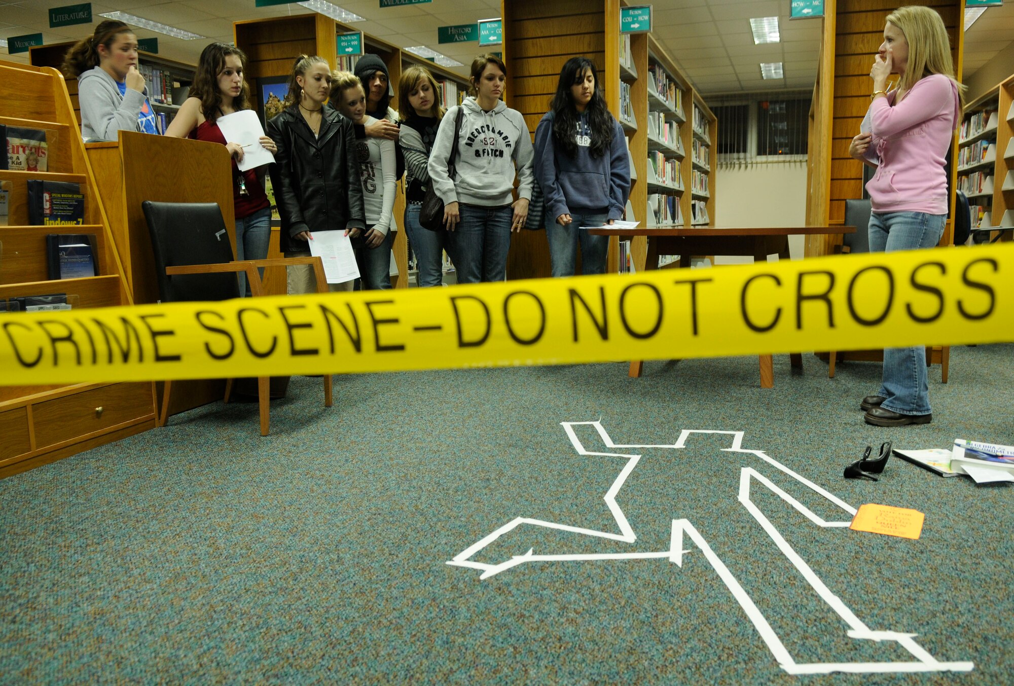 Incirlik Unit School students look on at the library’s Mystery Night as Patty Gill, Incirlik’s library programs director explains the first crime scene Feb 2.  The Mystery Night was open to all Incirlik Unit School students. (U.S. Air Force photo/Airman 1st Class Amber Russell)