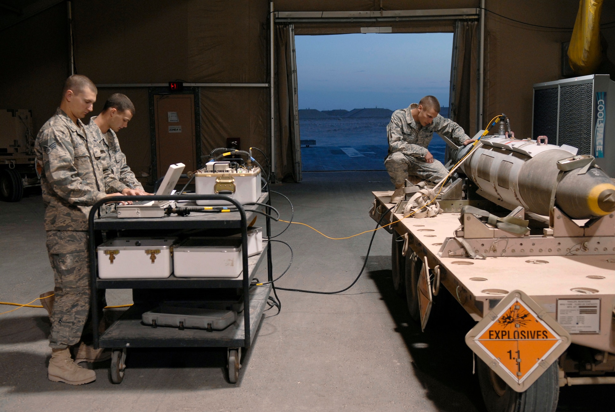 Senior Airman Richard Parvin (left to right), a 379th Expeditionary Maintenance Squadron (EMXS) Ammunitions Systems Journeyman, Airman 1st Class Brian Foster, a 379th EMXS Ammunitions Systems Journeyman, and Airman Bryan Newcomer, a 379th EMXS Ammunitions Systems Apprentice, perform routine checks on the convention ammunitions bit reprogramming equipment for the tail kit of GBU-31 bomb Feb. 3, 2009, at an undisclosed location in Southwest Asia.  Senior Airman Parvin hails from Birmingham, Ala.  Airman 1st Class Foster hails from Ellijay, Ga.  Airman Newcomer is from Suwanee, Ga.  The Airmen are all deployed from Dyess AFB., Texas in support of Operation Iraqi and Enduring Freedom and Combined Joint Task Foce- Horn of Africa.  (U.S. Air Force Photo by Airman 1st Class Andrew Satran/Released)