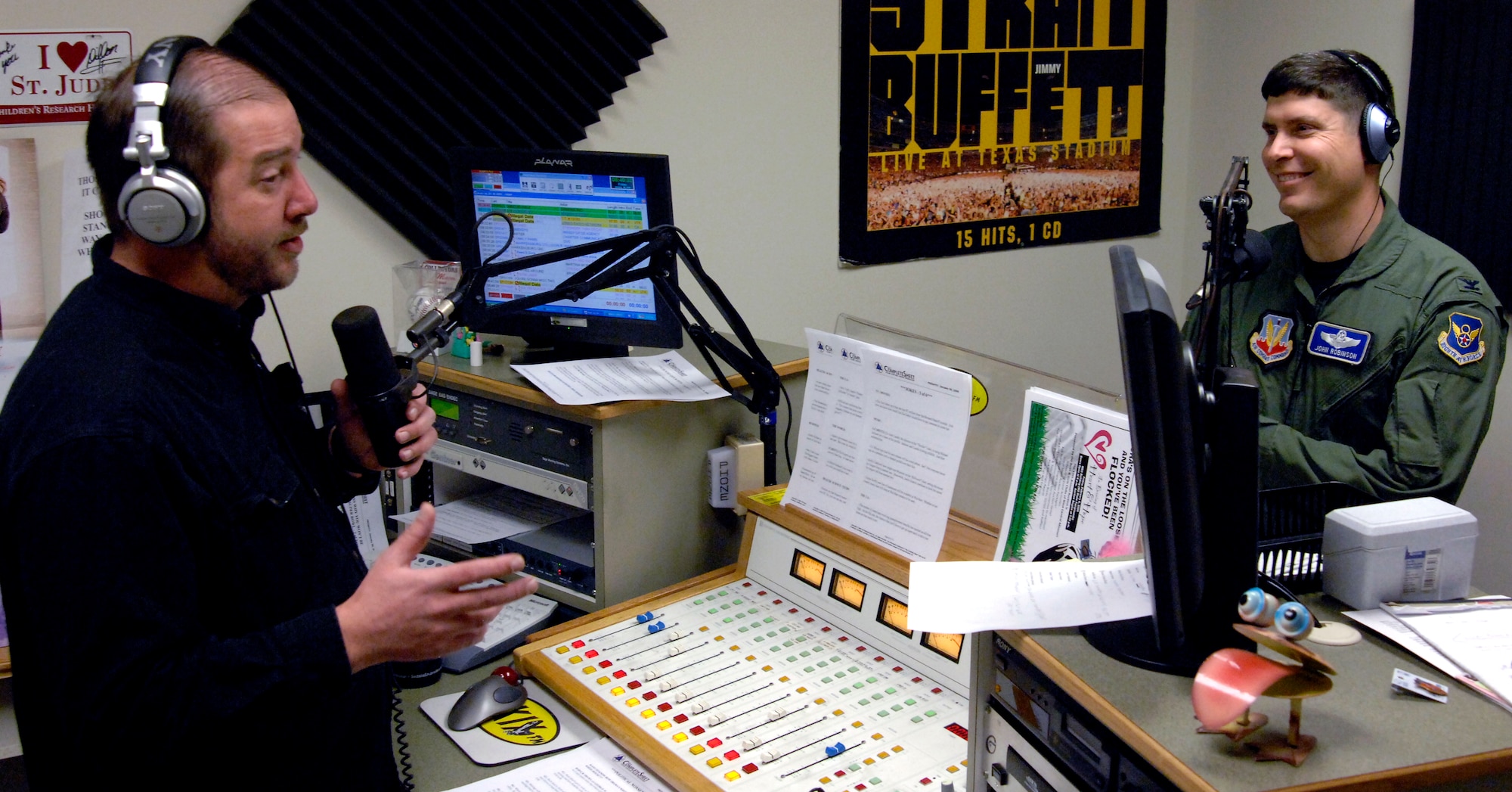 WHITEMAN AIR FORCE BASE, Mo. – Col. John Robinson, 509th Bomb Wing vice commander, laughs at Bruce Enrietto, a 105.7 FM KXKX morning host, during the “Bruce in the Morning” radio show. Colonel Robinson was a guest co-host for the "Bruce in the Morning" show Jan. 30 and talked about different aspects of Team Whiteman while on the air. 
