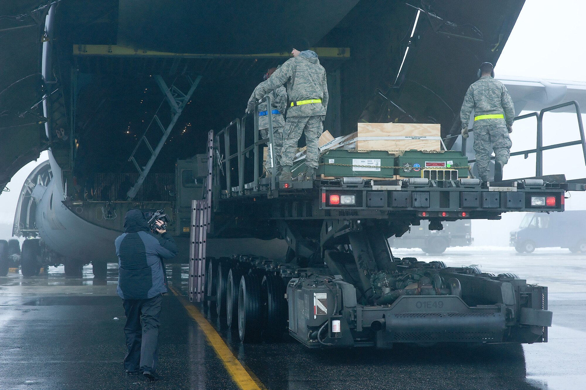 436th Aerial Port Squadron Airmen load pallets onto a C-5 Galaxy, while a filmcrew member captures the process on Dover Air Force Base Jan. 30. The crew was at Dover to film an Air Force Smart Operations for the 21st Century video, which is scheduled to be released to Air Force bases worldwide. (U.S. Air Force photo/Roland Balik)
