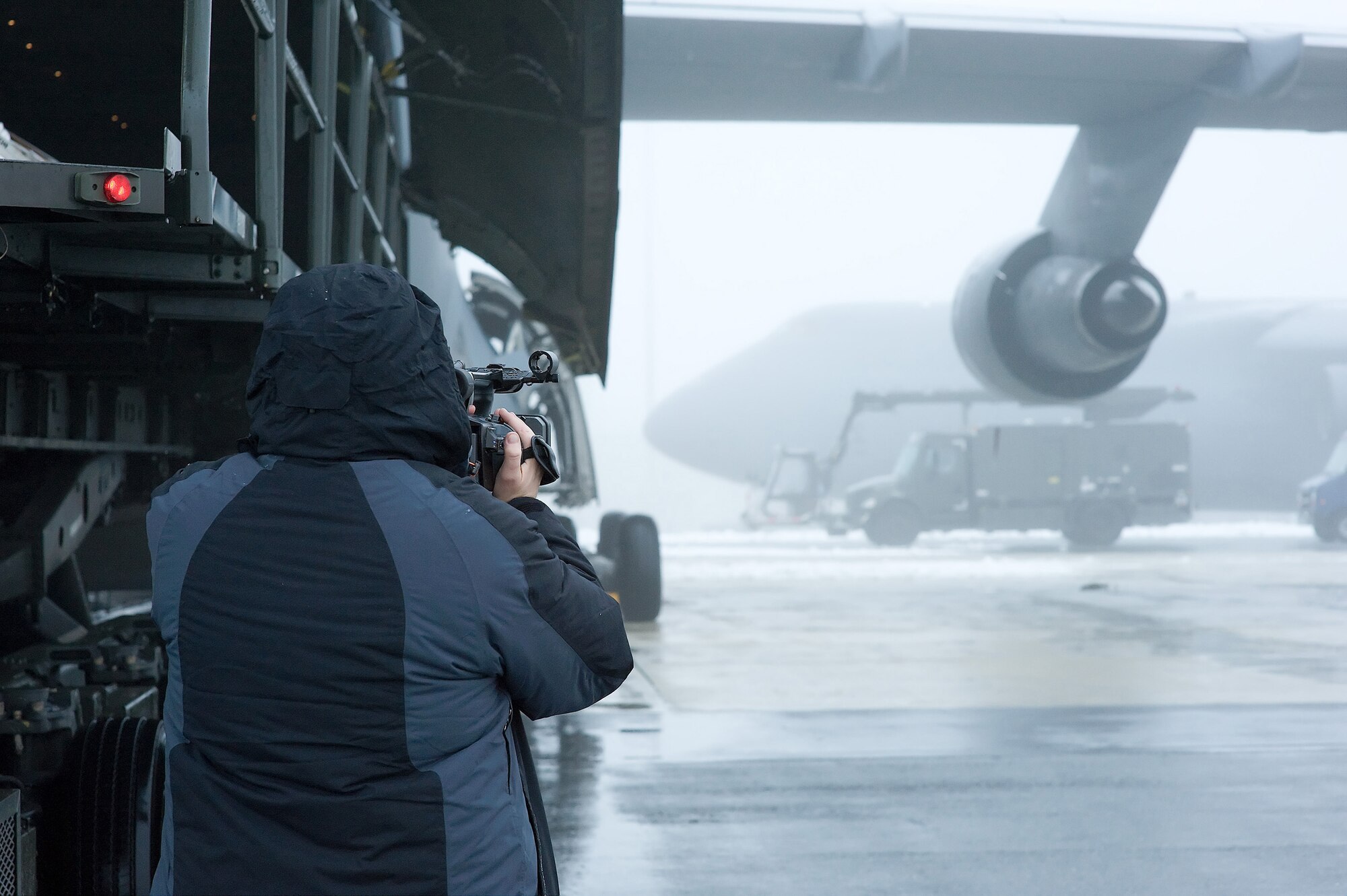 A filmcrew member captures a K-loader taxiing to an aircraft during their filming of an Air Force Smart Operations for the 21st Century video on Dover Air Force Base Jan. 30. Dover is home to the largest Aerial Port Squadron in the Department of Defense and plays a critical role in getting cargo to the warfighters. (U.S. Air Force photo/Roland Balik)