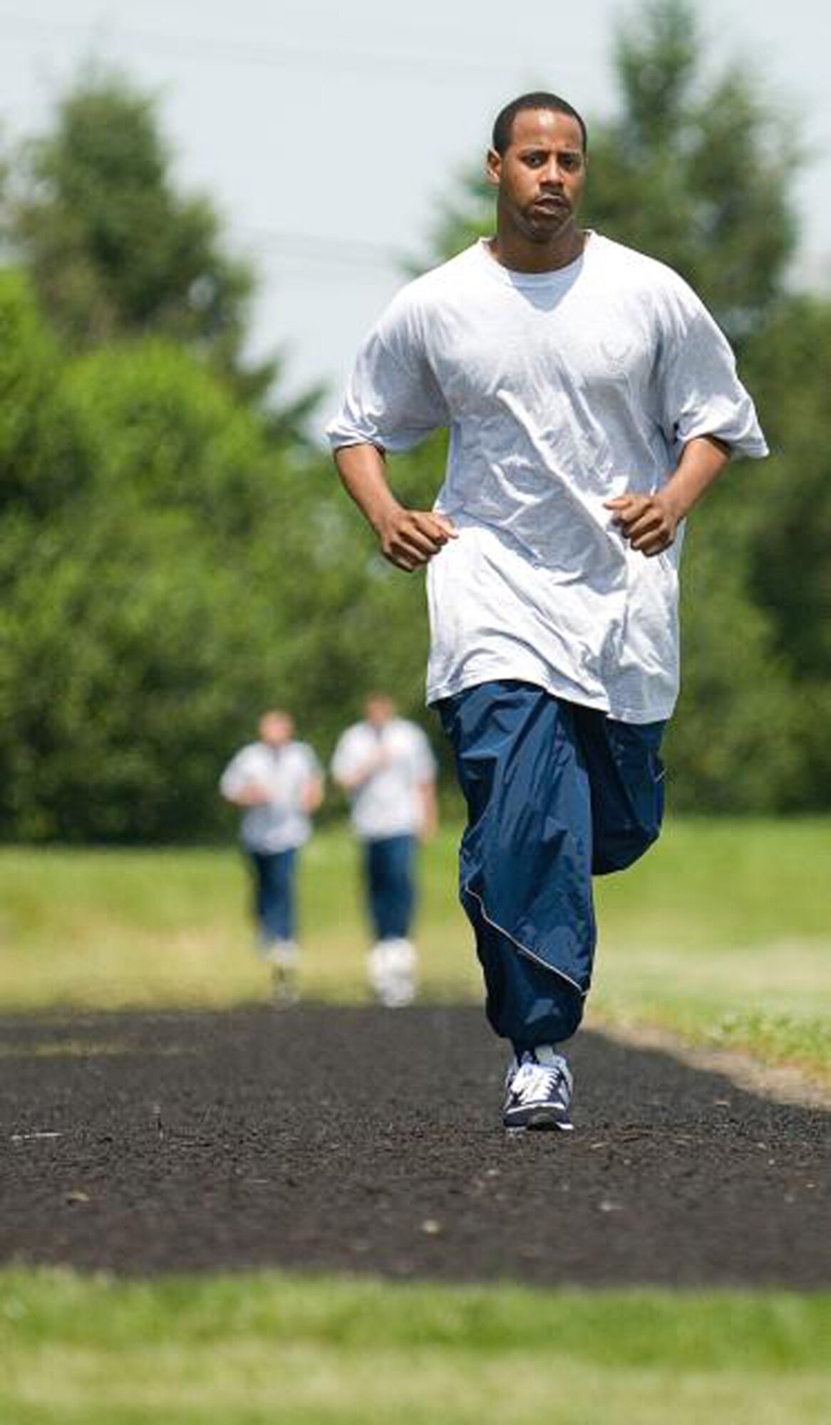 Senior Airman Marques Johnson, 436th Security Forces Squadron, runs on the base track as part of his squadron's monthly PT evaluation. (U.S. Air Force Photo / Roland Balik) 