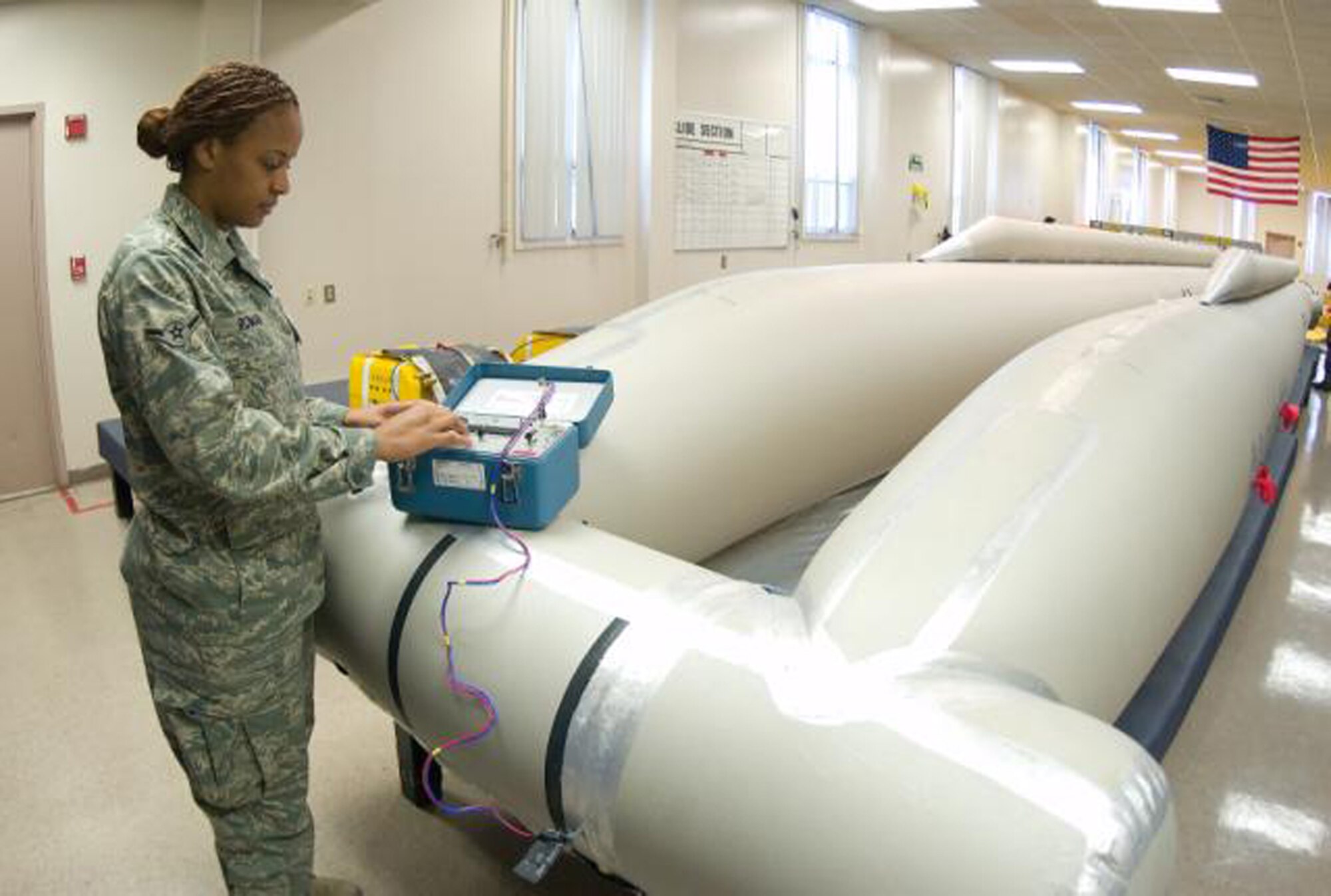 Airman Teneil Roman, 436th Operation Support Squadron, tests the battery on an C-5 Galaxy emergency escape slide. (U.S. Air Force Photo / Jason Minto) 