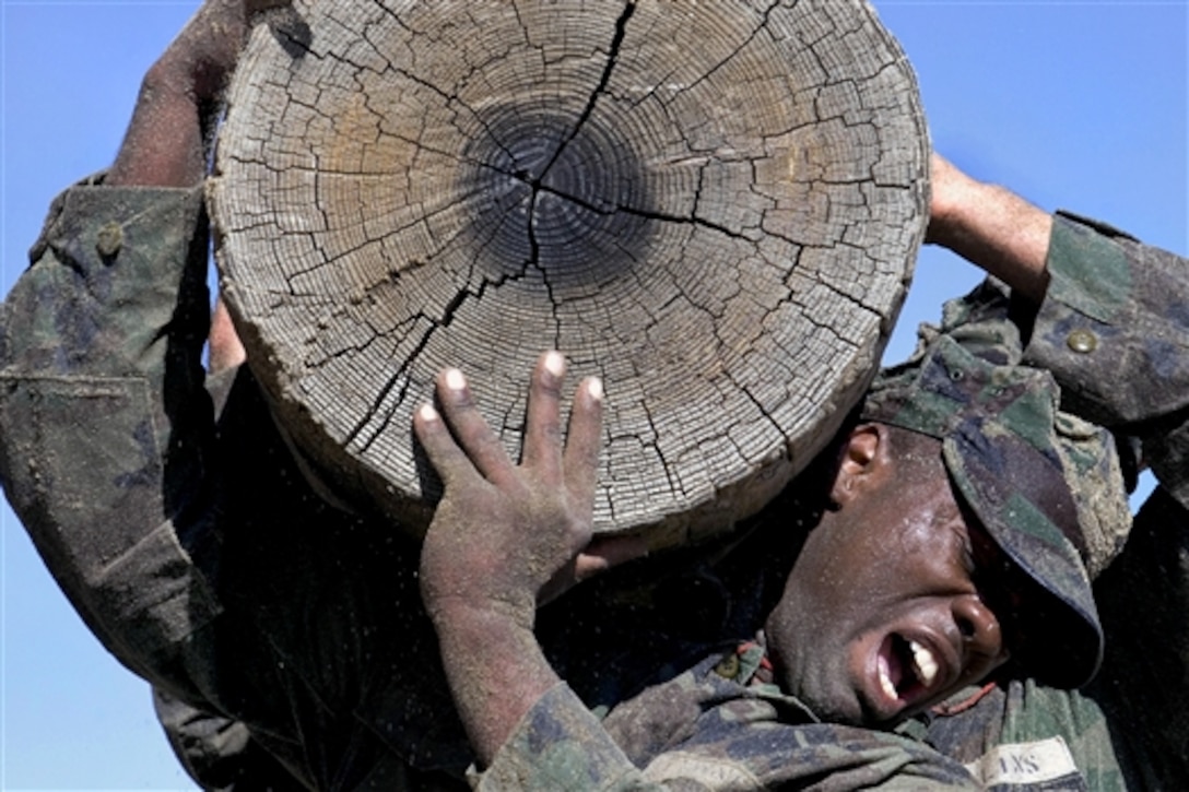 U.S. Navy Basic Underwater Demolition SEAL students lift Old Misery, a significantly larger log than other logs used during physical training, at the Naval Special Warfare Center on Naval Amphibious Base Coronado, Calif., Feb. 3, 2009.