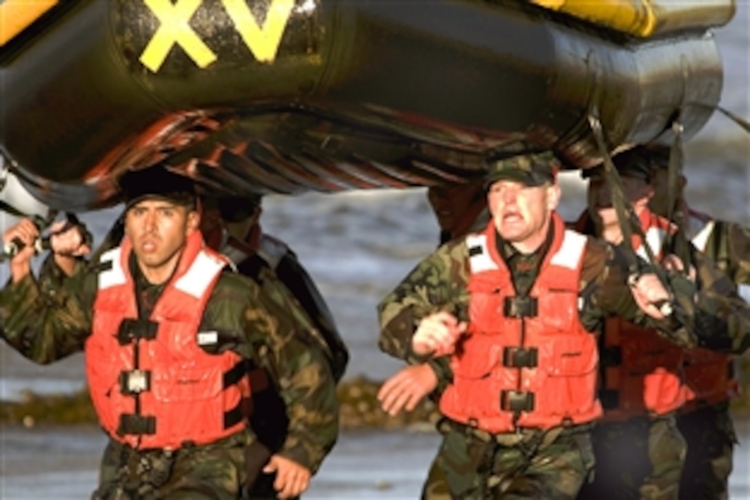 U.S. Navy SEAL students carry an inflatable boat along the beach at the Naval Special Warfare Center during their training at Naval Amphibious Base Coronado, Calif., Jan. 27, 2009. This exercise occurs during the first phase of basic underwater demolition training where students are tested mentally and physically.