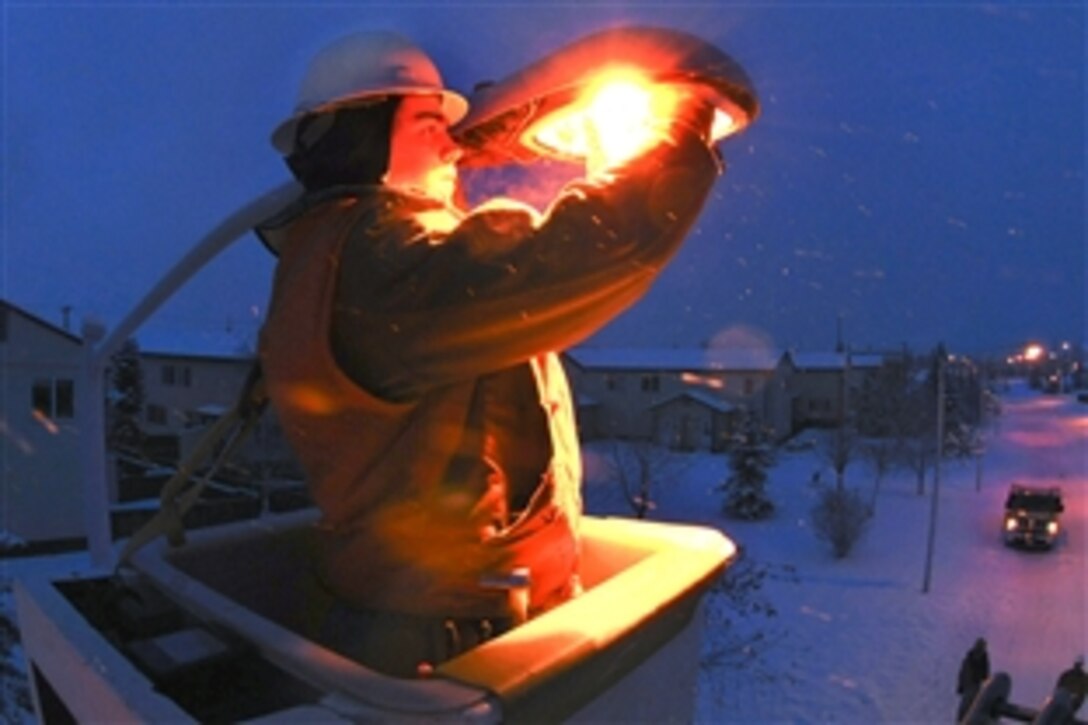 U.S. Air Force Senior Airman Scott Brown works on a street light on Eielson Air Force Base, Alaska, Feb. 2, 2009. Brown is hoisted by a 45- foot high reach bucket truck to access to the bulb. The arctic environment and constant use during winter months causes wear and tear on the street lamps.