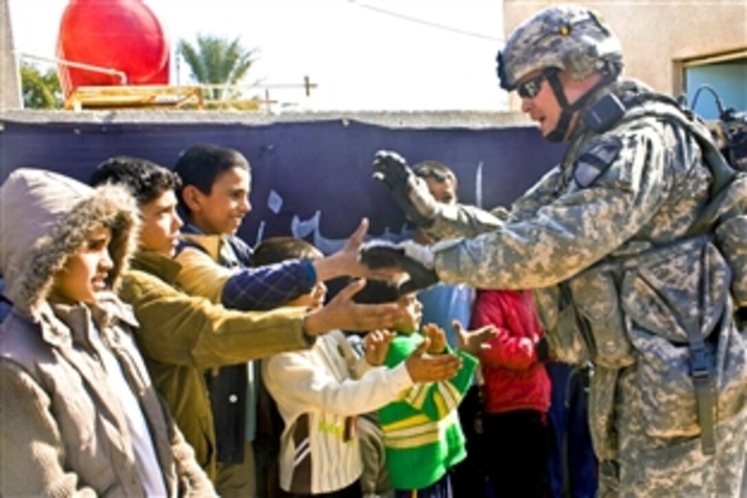 A U.S. Army soldier plays with Iraqi children waiting in line during a medical assistance mission near Forward Operating Base Hunter, Iraq, Jan. 25, 2009. The soldiers are assigned to 1st Squadron, 9th Cavalry Regiment, 4th Brigade Combat Team, 1st Cavalry Division.