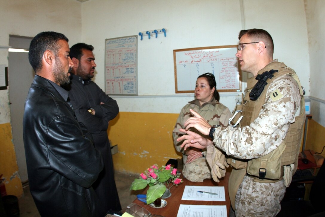 Capt. Justin Martell (right), the battalion judge advocate for 2nd Battalion, 25th Marine Regiment, Regimental Combat Team 8, discusses a claims case with Fahig Mohammed Beder (front, left), an Iraqi lawyer, and his client during a damage claims session at the police station in Rutbah, Iraq Feb. 5. (Official USMC photo by Capt. Paul L. Greenberg)