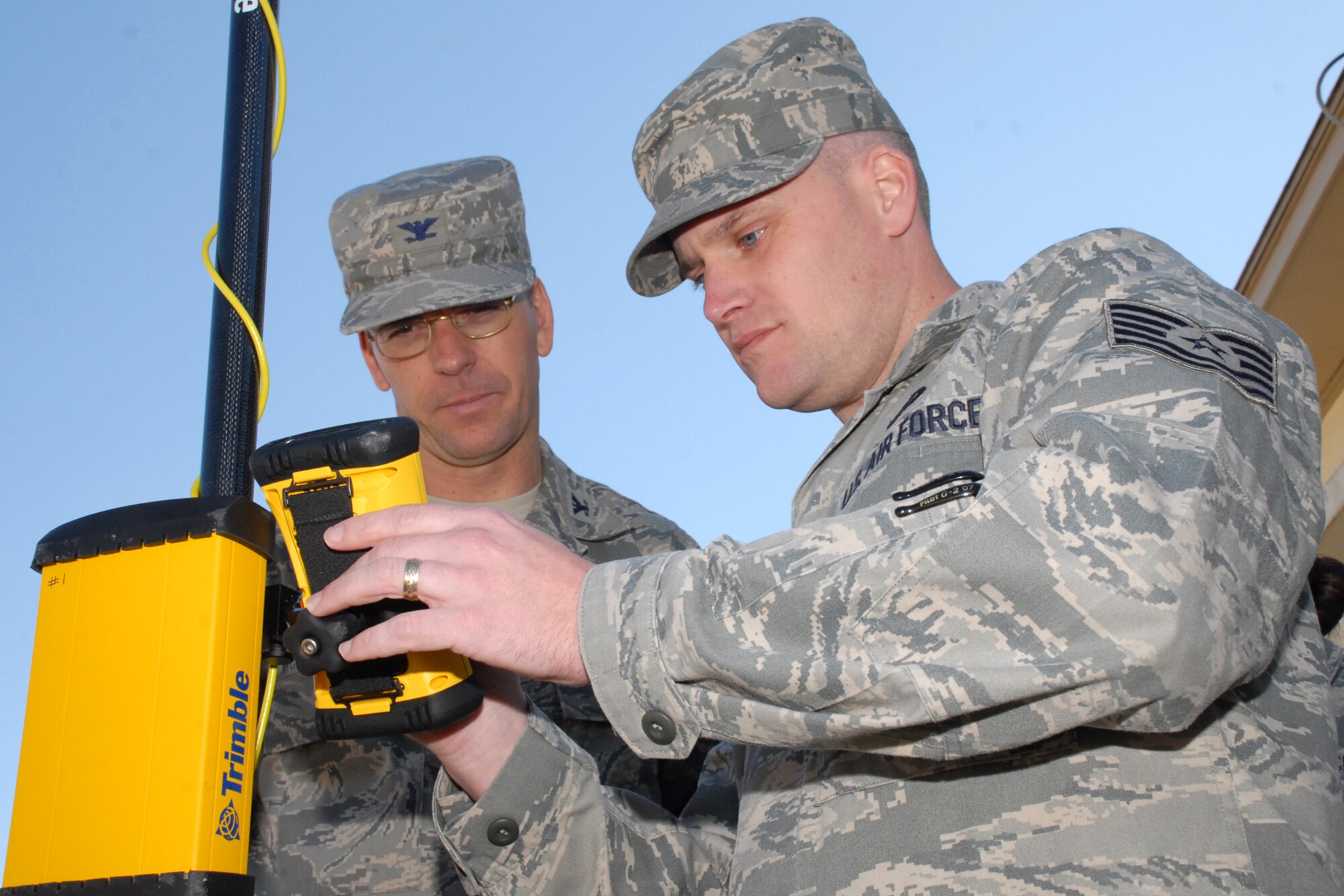 EGLIN AIR FORCE BASE, Fla. -- Tech. Sgt. Harley Campbell, 96th Communication Squadron cable and antenna systems, goes over the Trimble with Col. Bruce McClintock, 96th Air Base Wing commander, during a weekly walkabout Jan. 30. The Trimble is a Global Position System used to locate and mark buried cable and infrastructure around Eglin's 724 square miles of land. The squadron is responsible for providing command, control and communications capability to more than 243,000 military and civilian aircraft operations per year. Colonel McClintock and Chief Master Sgt. Troy Engholm, 96th ABW command chief master sergeant, take a weekly walkabout visit to the units on base to applaud their successes and determine their needs for mission accomplishment. (U.S. Air Force photo by Staff Sgt. Mike Meares)