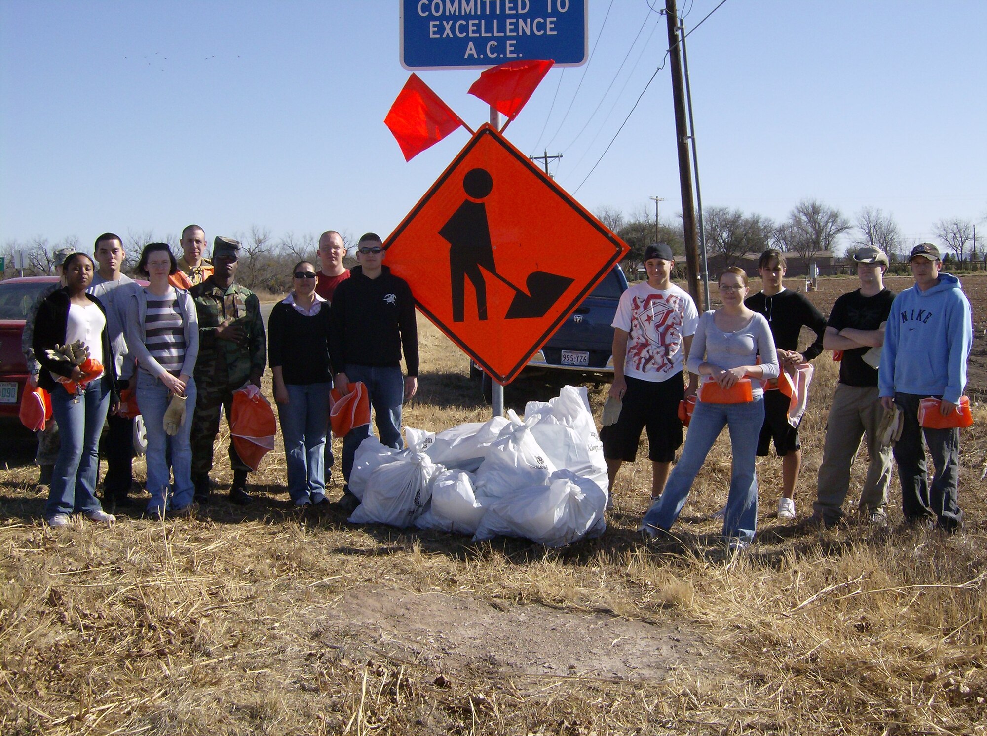 Members of the Armed Forces Committed to Excellence (ACE) organization pose by their collected trash off Chadbourne St. during their Adopt-a-Highway cleanup Jan 30. (U.S. Air Force photo by Airman 1st Class Robert Fox-Stowe)