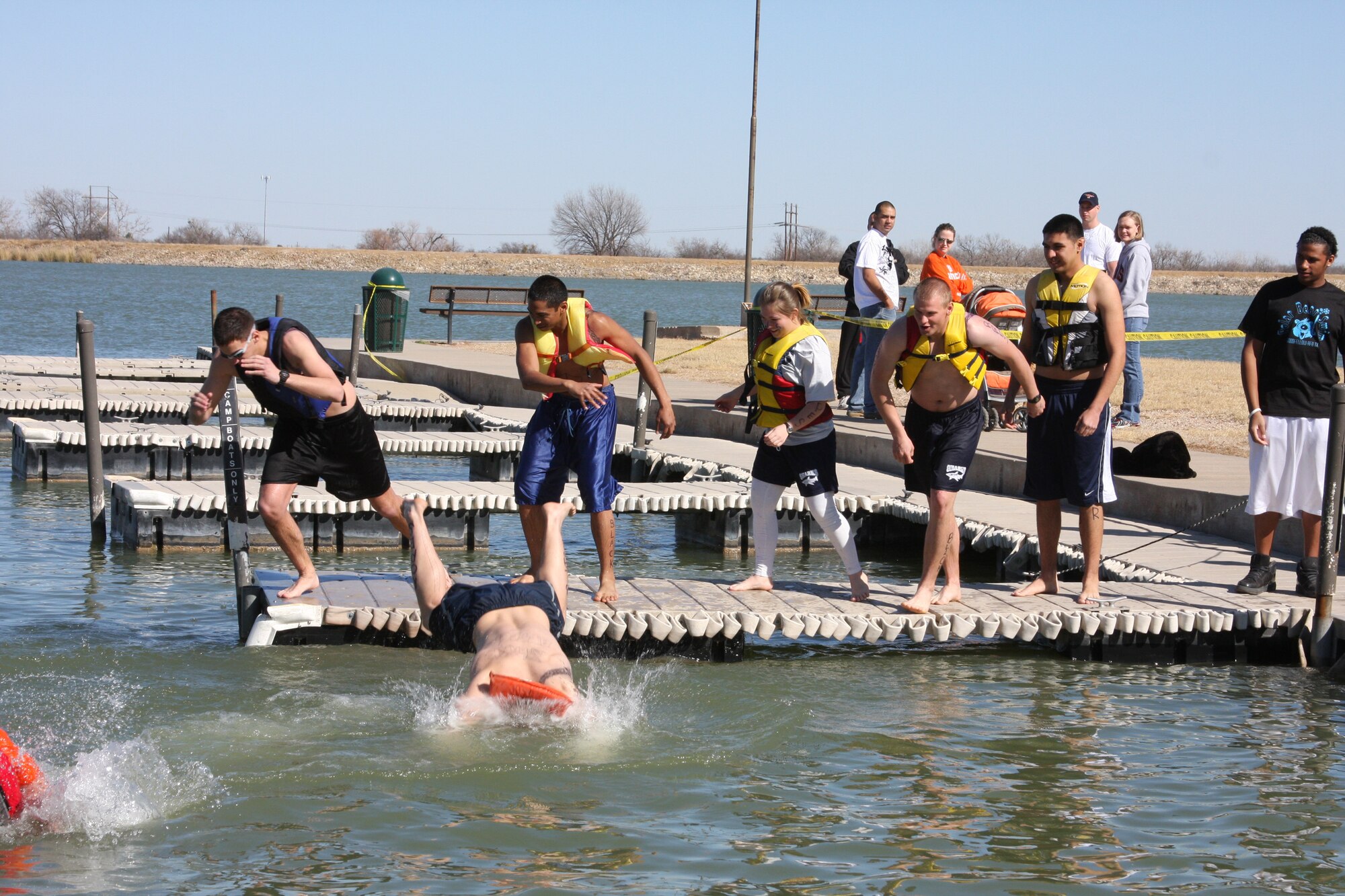 Airmen from Goodfellow Air Force Base leave the dock during the annual Polar Bear Swim Jan. 31 at the Goodfellow Recreation Camp at Lake Nasworthy. The 316th Training Squadron won the trophy for having the most members of their unit jump in the water at the event, which tests the endurance of our battle-ready Airmen, Soldiers, Sailors and Marines. (U.S. Air Force photo by Julie Manuel)