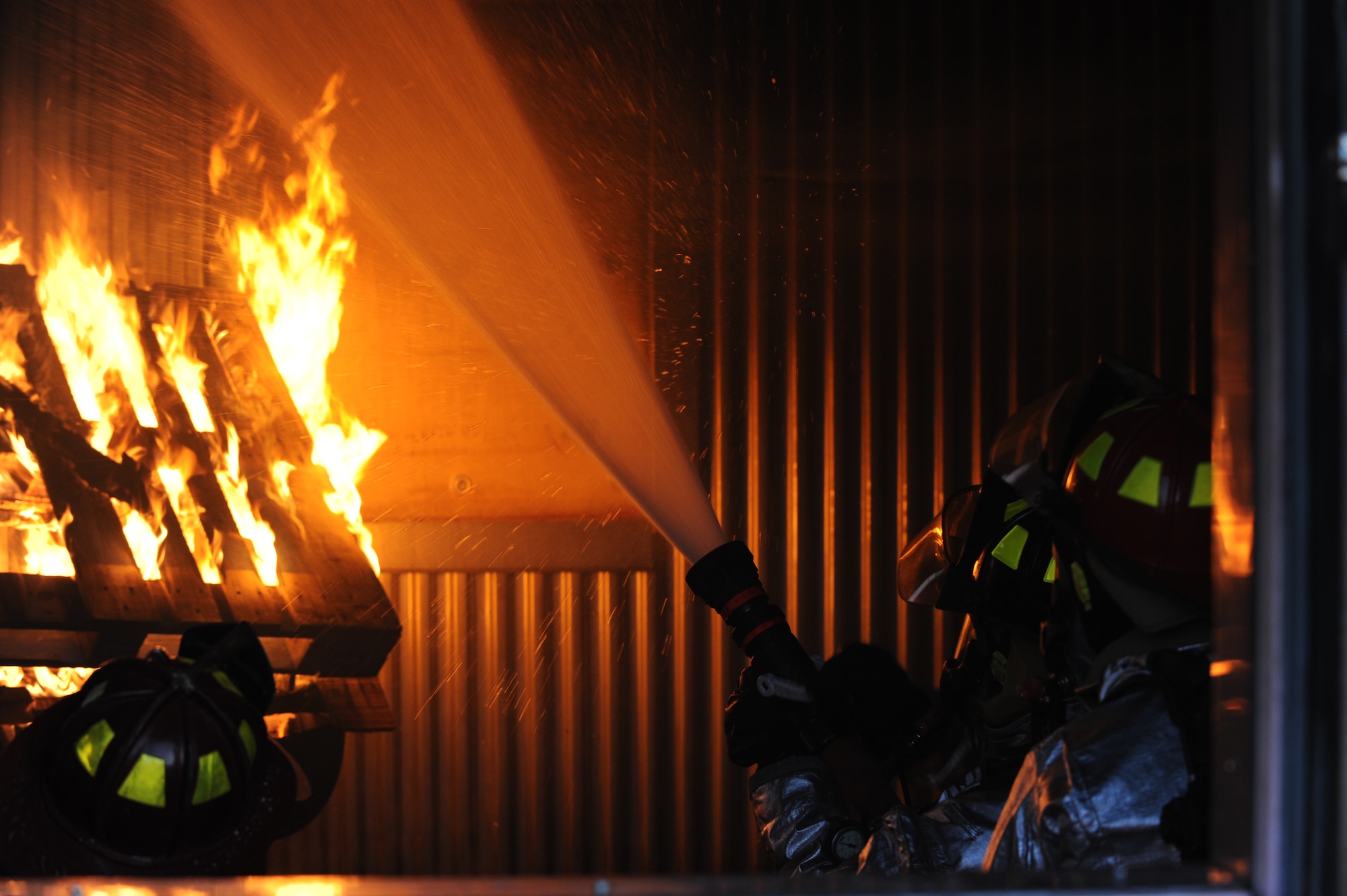 Members of the 28th Civil Engineer Squadron fire department spray water on a simulated structural fire during a training exercise at Ellsworth Air Force Base, S.D., Feb. 4, 2009. The simulated structural fires allow firefighters to safely practice extinguishing fires to maintain operational readiness. (U.S. Air Force photo/Airman 1st Class Joshua J. Seybert)