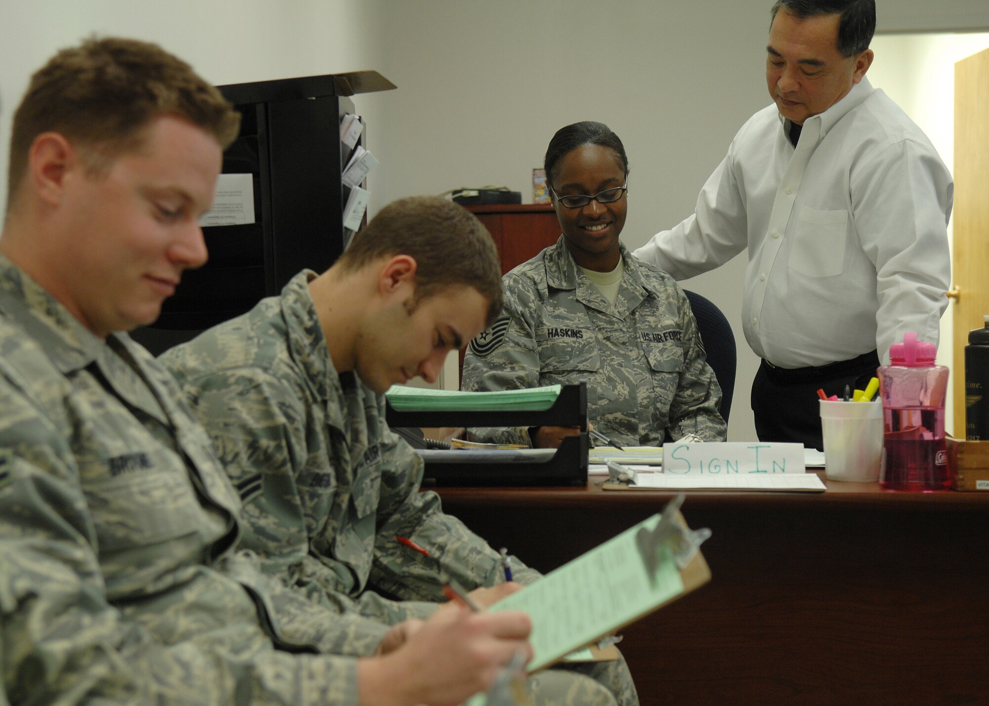 Airman 1st Class Lawrence Broome and Airman 1st Class Brad Biesinger, both 49th Logistics Readiness Squadron, wait to be assisted by Tech. Sgt. Tynisa Haskins, 49th Fighter Wing Tax Center manager, and Teddy Beldad, 49th Security Forces Squadron tax volunteer at the Tax Center located in building 29 at Holloman Air Force Base, N.M., Feb. 4. The Tax Center will be open until April 15, the last day income taxes can be regularly filed without penalty. To make an appointment, call the Tax Center at 572-1040. (U.S. Air Force photo/Staff Sgt. Anthony Nelson Jr.)