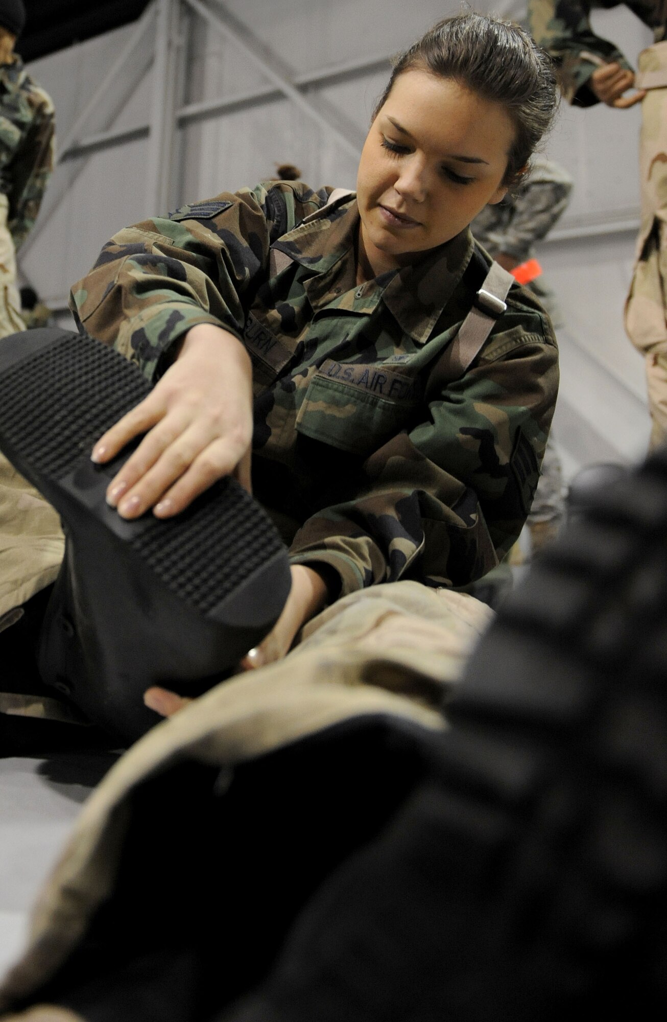 LANGLEY AIR FORCE BASE, Va. -- Senior Airman Rachel Washburn pulls chemical warfare gear on while dressing during an Ability to Survive and Operate Rodeo here Feb. 4. The rodeo provided training to more than 700 Airmen to prepare them for deployment.   (U.S. Air Force photo/Airman Rebecca Montez)