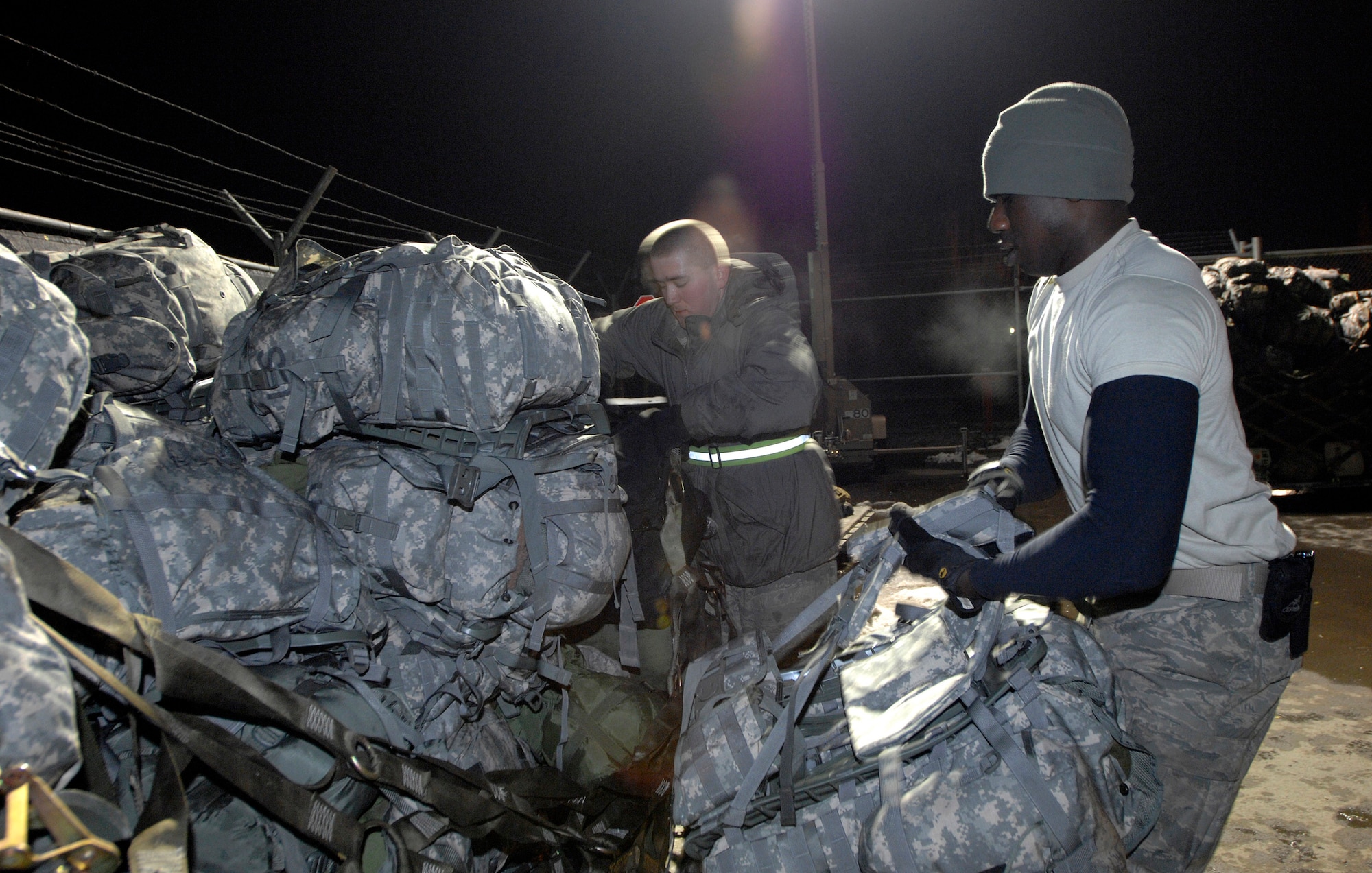 Airmen 1st Class Jake Moennich (right) and Shaun Brown palletize duffle bags, backpacks and other deployment gear to be airlifted U.S. forces members being deployed to Afghanistan Feb. 4 at Manas Air Base, Kyrgyzstan. Manas AB serves as a mobility hub for operations in Afghanistan, providing daily refueling missions and supporting personnel and cargo transiting in and out of Afghanistan. Airman Brown and Moennich are both with the 376th Expeditionary Logistics Readiness Squadron and are deployed from McConnell Air Force Base, Kan. (U.S. Air Force photo/Tech. Sgt. Phyllis Hanson) 
