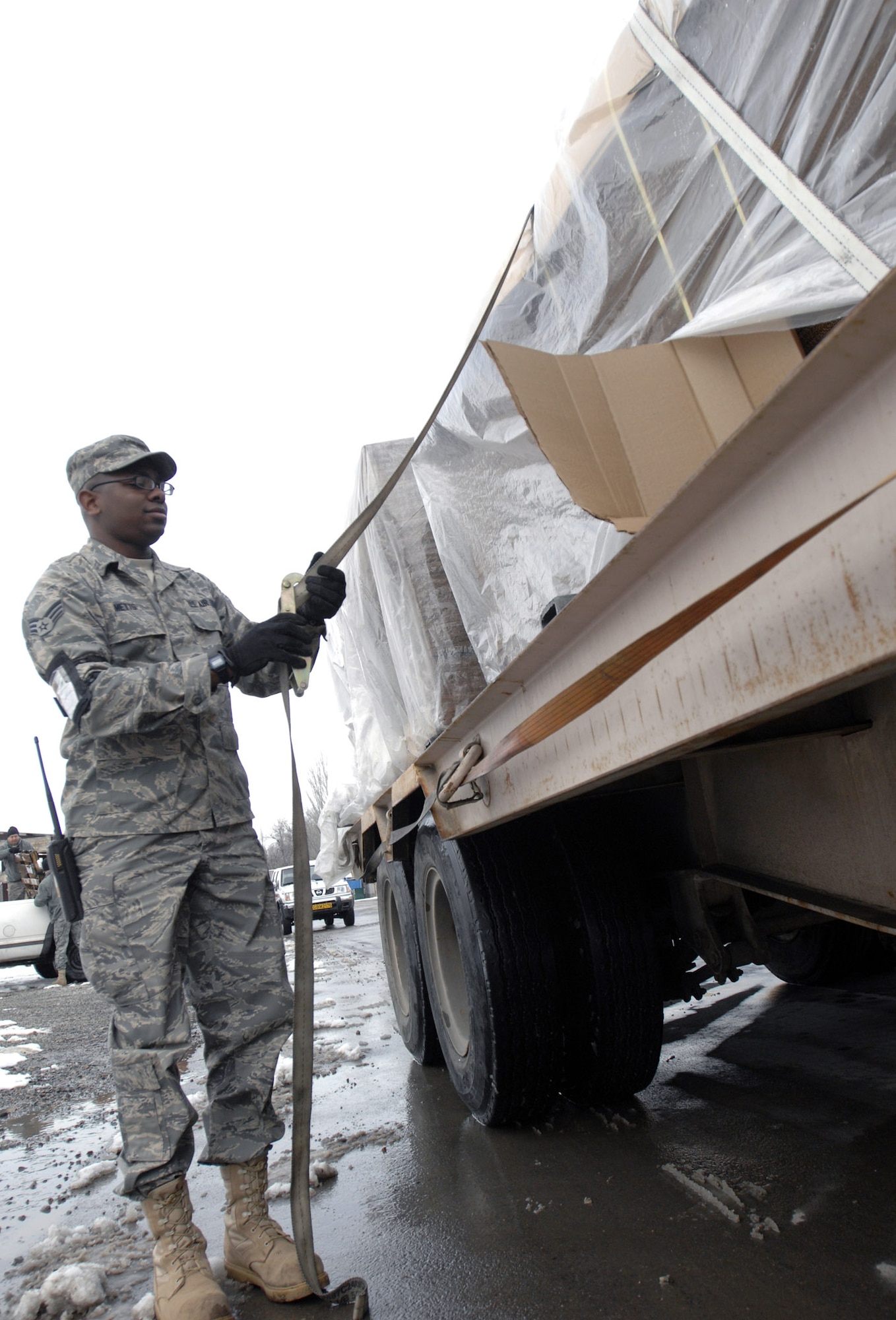 Airman 1st Class Timothy Metts loosens the straps off a pallet of triwall boxes Feb. 4 at Manas Air Base, Kyrgyzstan. The boxes will be used for shipping military equipment to and from Afghanistan. Manas AB serves as a mobility hub for operations in Afghanistan, providing daily refueling missions and supporting personnel and cargo transiting in and out of Afghanistan. Airman Metts is with the 376th Expeditionary Logistics Readiness Squadron and is deployed from Aviano Air Base, Italy. (U.S. Air Force photo/Tech. Sgt. Phyllis Hanson) 
