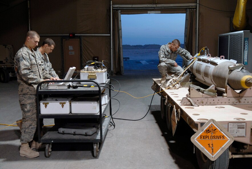 Senior Airman Richard Parvin (left to right), Airman 1st Class Brian Foster and Airman Bryan Newcomer perform routine checks on the convention ammunitions bit reprogramming equipment for the tail kit of a guided bomb unit-31 Feb. 3 at an air base in Southwest Asia. Airmen Parvin and Foster are 379th Expeditionary Maintenance Squadron ammunitions systems journeymen. Airman Parvin hails from Birminghman, Ala. Airman Foster is from Ellijay, Ga., Airman Newcomer is a 379th EMXS ammunitions systems apprentice and hails from Suwanee, Ga. (U.S. Air Force photo/Airman 1st Class Andrew Satran) 