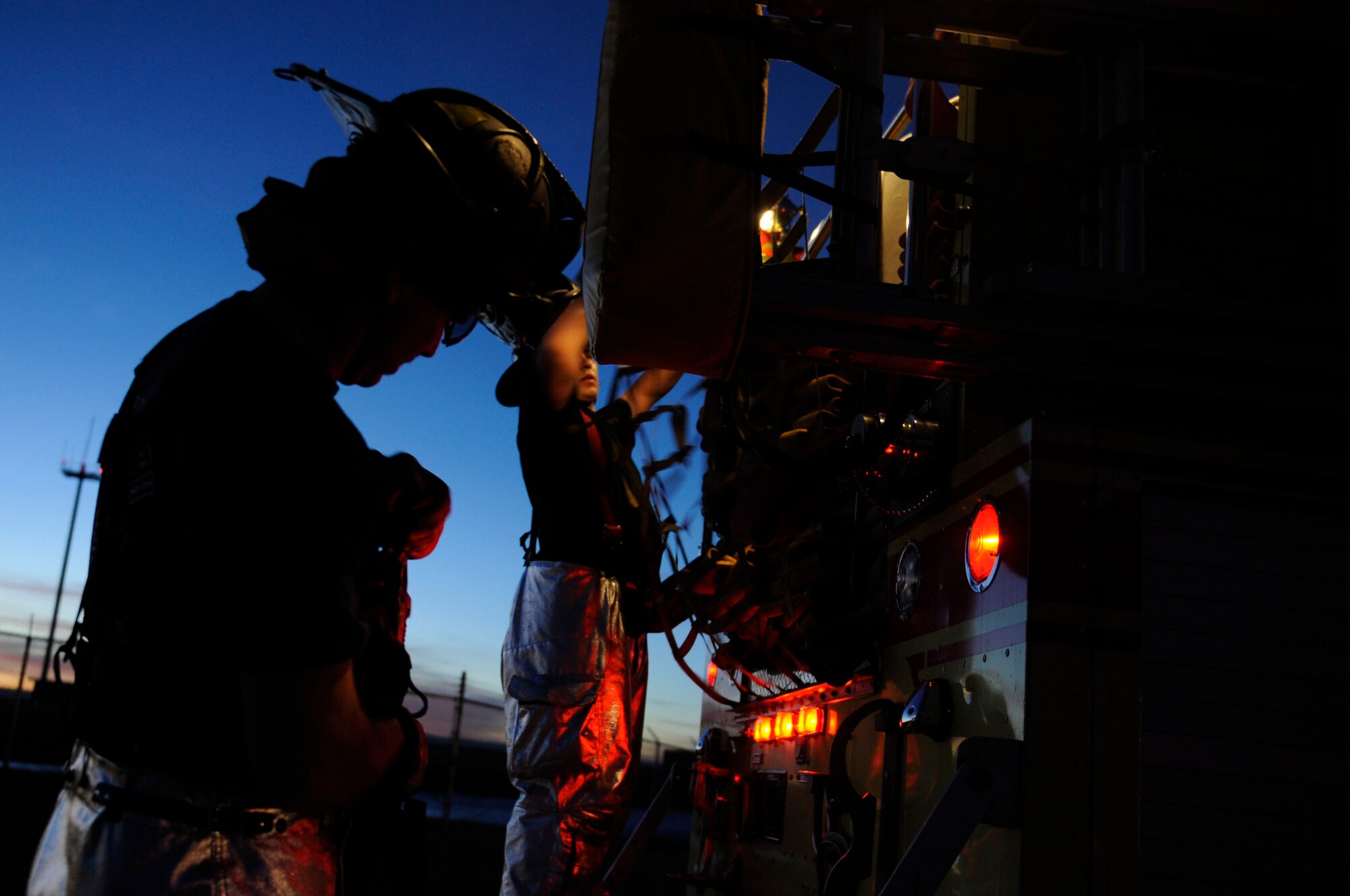 (Left to Right) Senior Airman Adam VanderZanden, 28th Civil Engineer operator, and Airman 1st Class John Vasquez, 28th CES firefighter, finish placing a hose into a fire truck during structural fire training here, Feb. 4. Simulated structural fires are conducted regularly to ensure Ellsworth firefighters maintain operational readiness and meet proper training requirements. (US Air Force photo/Airman 1st Class Corey Hook)