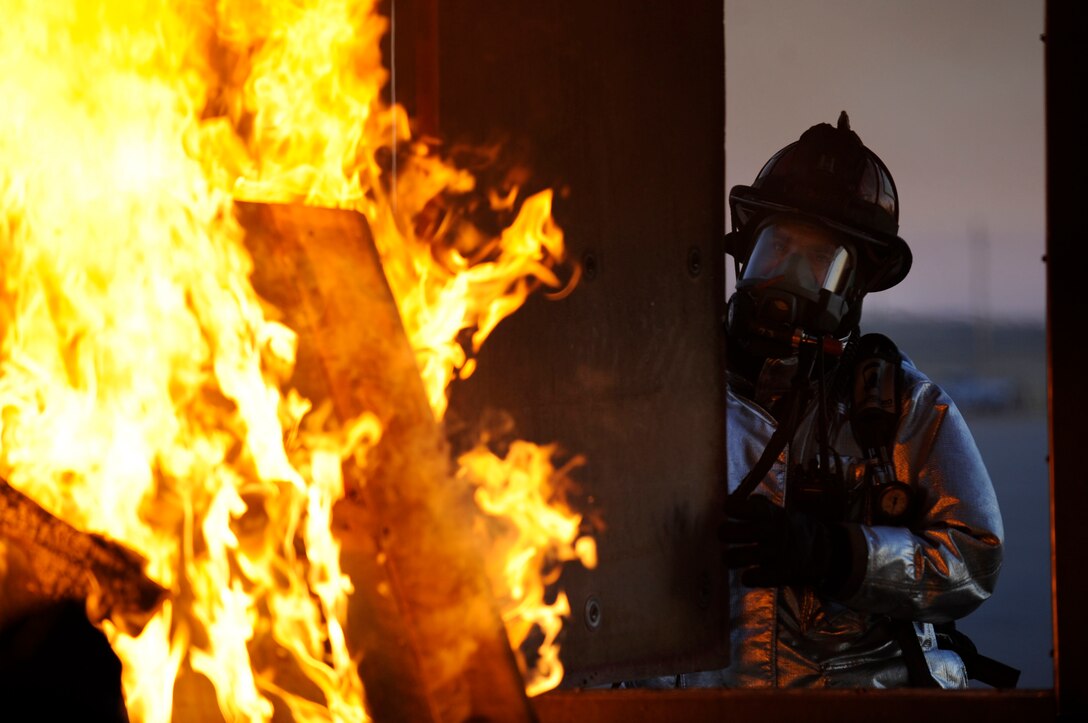 Douglas Fischer, 28th Civil Engineer Squadron crew chief, shuts a ventilation window during a structural training fire here, Feb. 4. Shutting the window creates a hotter environment inside the training building for simulation purposes. (US Air Force photo/Airman 1st Class Corey Hook)