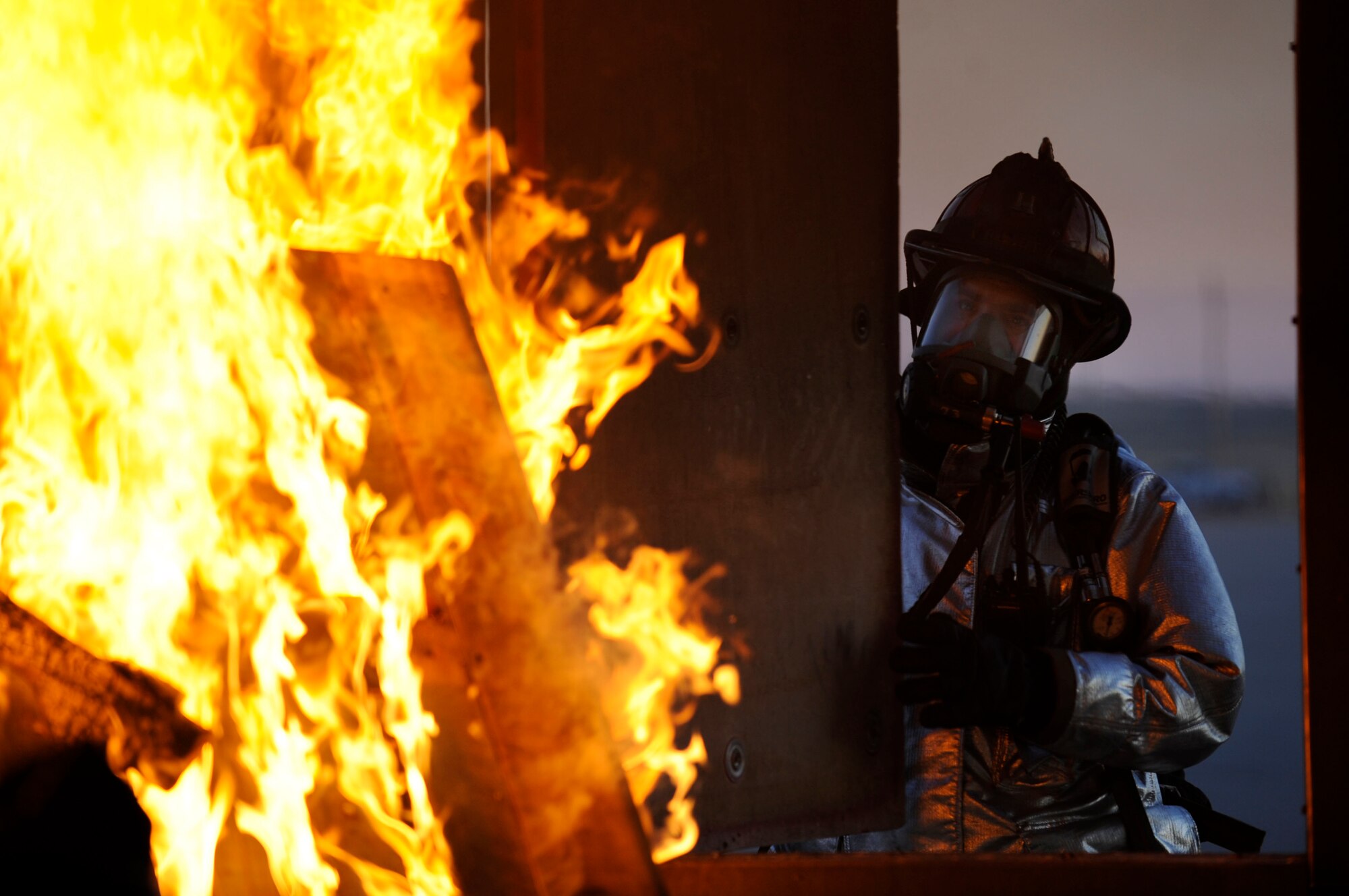 Douglas Fischer, 28th Civil Engineer Squadron crew chief, shuts a ventilation window during a structural training fire here, Feb. 4. Shutting the window creates a hotter environment inside the training building for simulation purposes. (US Air Force photo/Airman 1st Class Corey Hook)