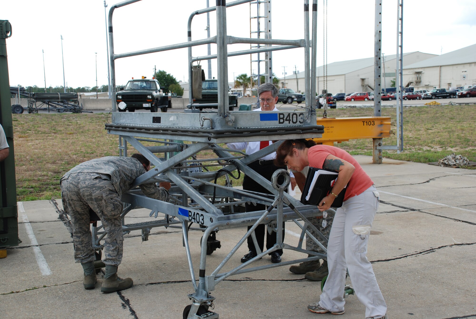Senior Master Sgt. Donald "Scott" Ward, David Ellicks and Ruth Jett, members of the Air Force Corrosion Prevention and Control Office, inspect an aircraft maintenance stand at Eglin Air Force Base, Fla., that had been sprayed with a unique coating material. Courtesy photo