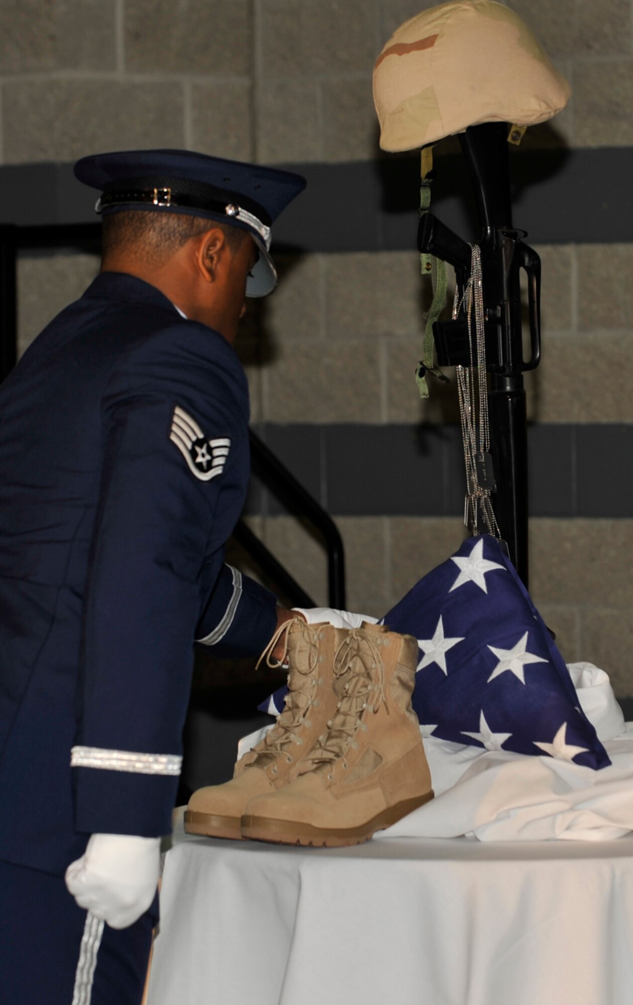 MOODY AIR FORCE BASE, Ga. -- Staff Sgt. Anthony Wilson, member of the Moody Air Force Base Honor Guard, places the American flag on the table of the fallen warrior tribute during the Annual Awards ceremony held Jan 31 here. Sergeant Wilson and other members of the Honor Guard participated in the fallen warrior tribute that pays honors all Airmen who have sacrificed their all. (U.S. Air Force photo by Senior Airman Schelli Jones)