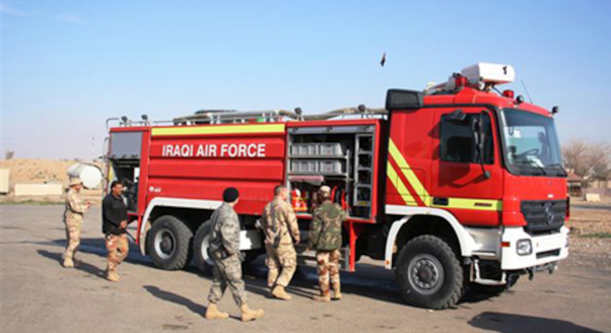 Staff Sgts. Manuel Ortez and Joseph Wysocki from the 512th Airlift Wing, Dover Air Force Base, Del., oversee the placement of equipment on an Iraqi air force fire truck with their Iraqi counterparts. Eight firefighters from the Air Force Reserve Command wing deployed to Kirkuk Regional Air Base, Iraq, Jan. 3, 2009. (U.S. Air Force photo)

