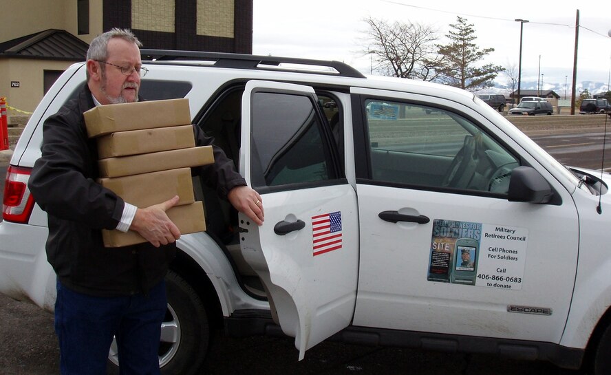 Denis Miller carries packages of old cell phones into the Malmstrom post office Feb. 2. The packages will be sent to a recycling center in Michigan and $5 for each cell phone will be donated to the Cell Phones for Soldiers program on behalf of the Montana Retiree's Council. (U.S. Air Force courtesy photo/Gloria Miller) 
