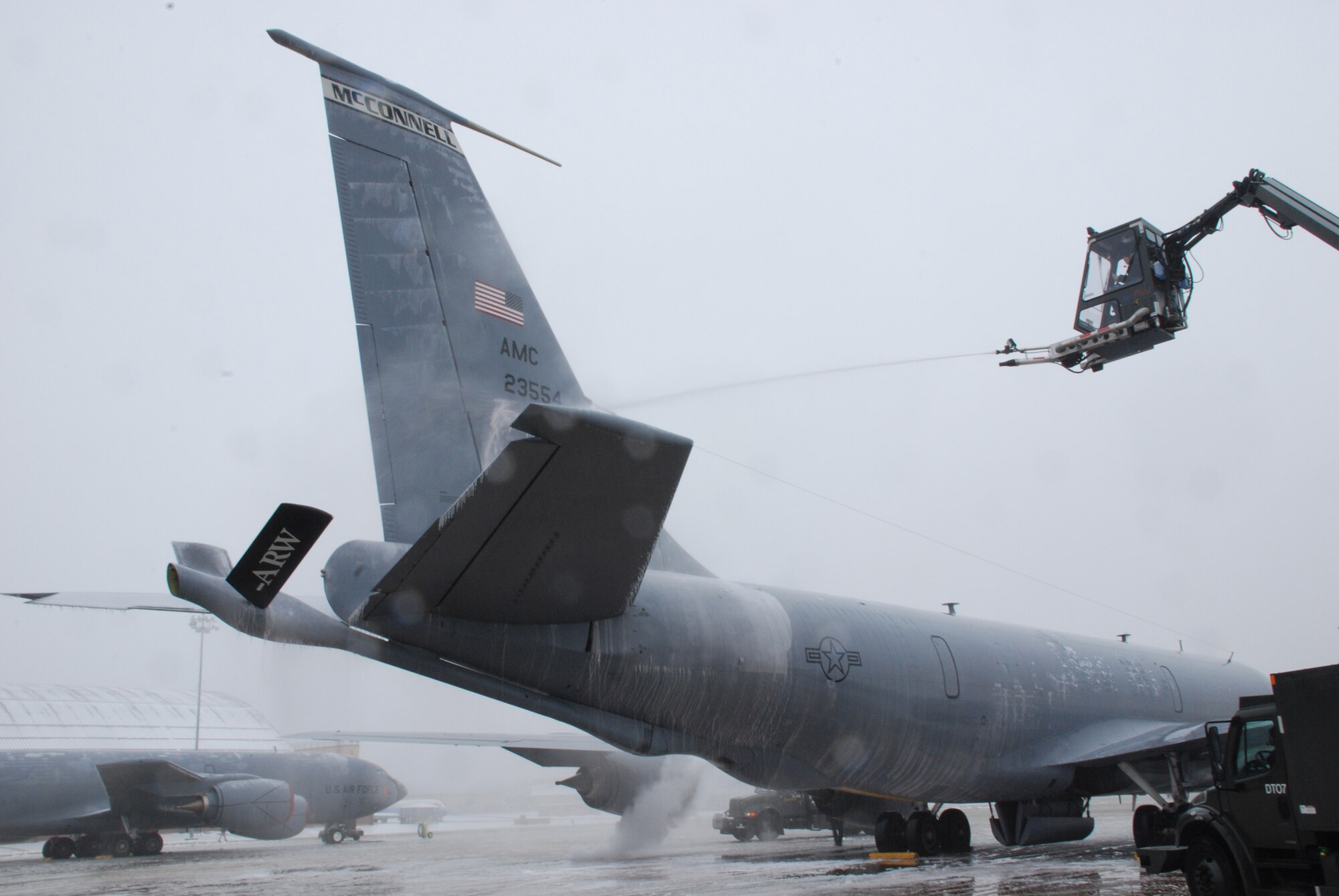 A member of the Air Force team at Andrews Air Force Base, Md., sprays a KC-135 Stratotanker with a de-icing solution. Reservists from the 931st Air Refueling Group landed the tanker at Andrews during a 12-day aeromedical evacuation mission. The 931st is an Air Force Reserve unit at McConnell Air Force Base, Kan. (Courtesy photo/Tech. Sgt. Warren Bearup) 