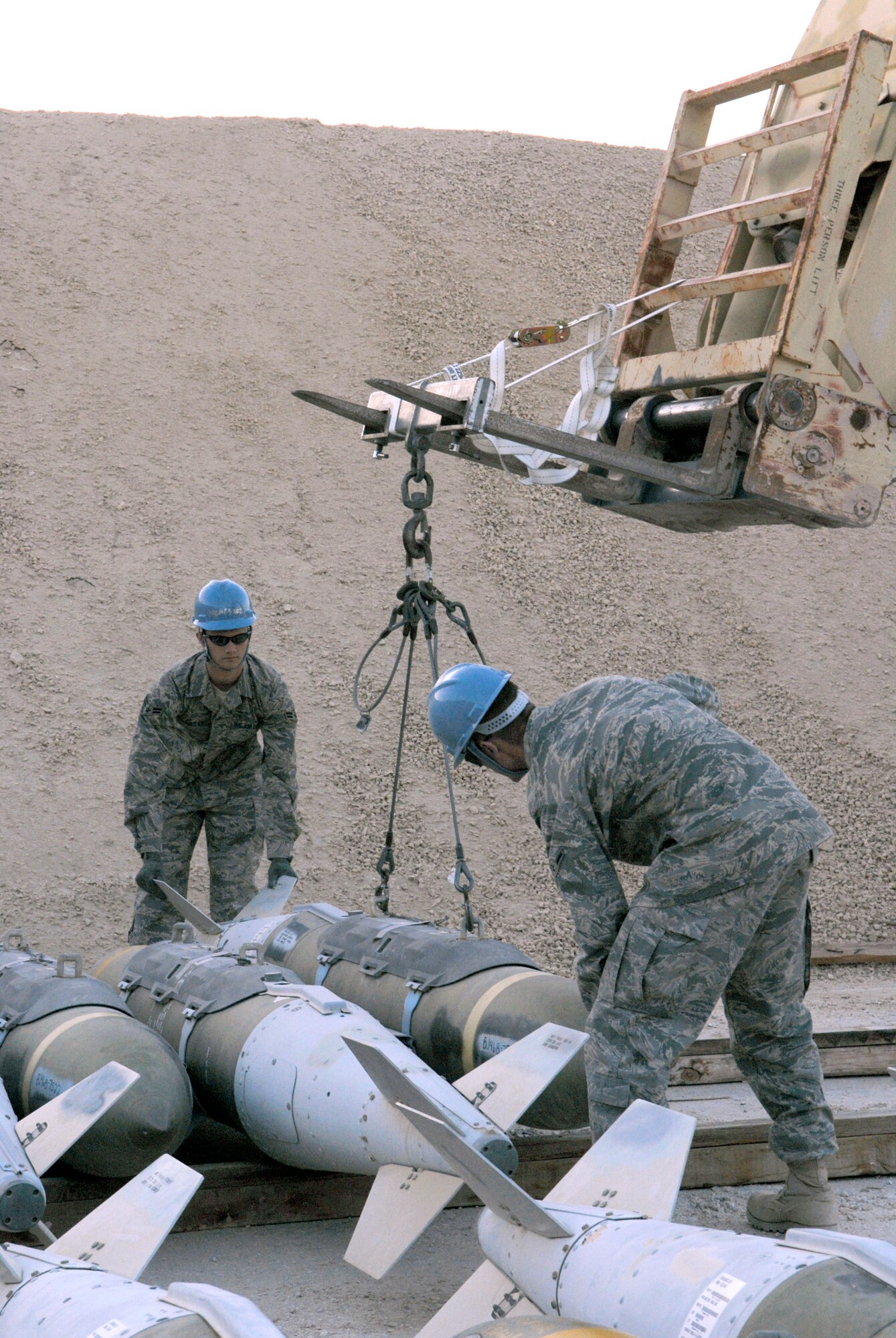 Airman 1st Class Brian Foster and Airman Bryan Newcomer move guided bomb unit-31s during the annual munitions serviceability inspection Feb. 3 at an air base in Southwest Asia. Airman Foster is a 379th Expeditionary Maintenance Squadron ammunitions systems journeymen from Ellijay, Ga., and Airman Newcomer is a 379th EMXS ammunitions systems apprentice and hails from Suwanee, Ga. Both are deployed from Dyess Air Force Base, Texas. (U.S. Air Force photo/Airman 1st Class Andrew Satran) 
