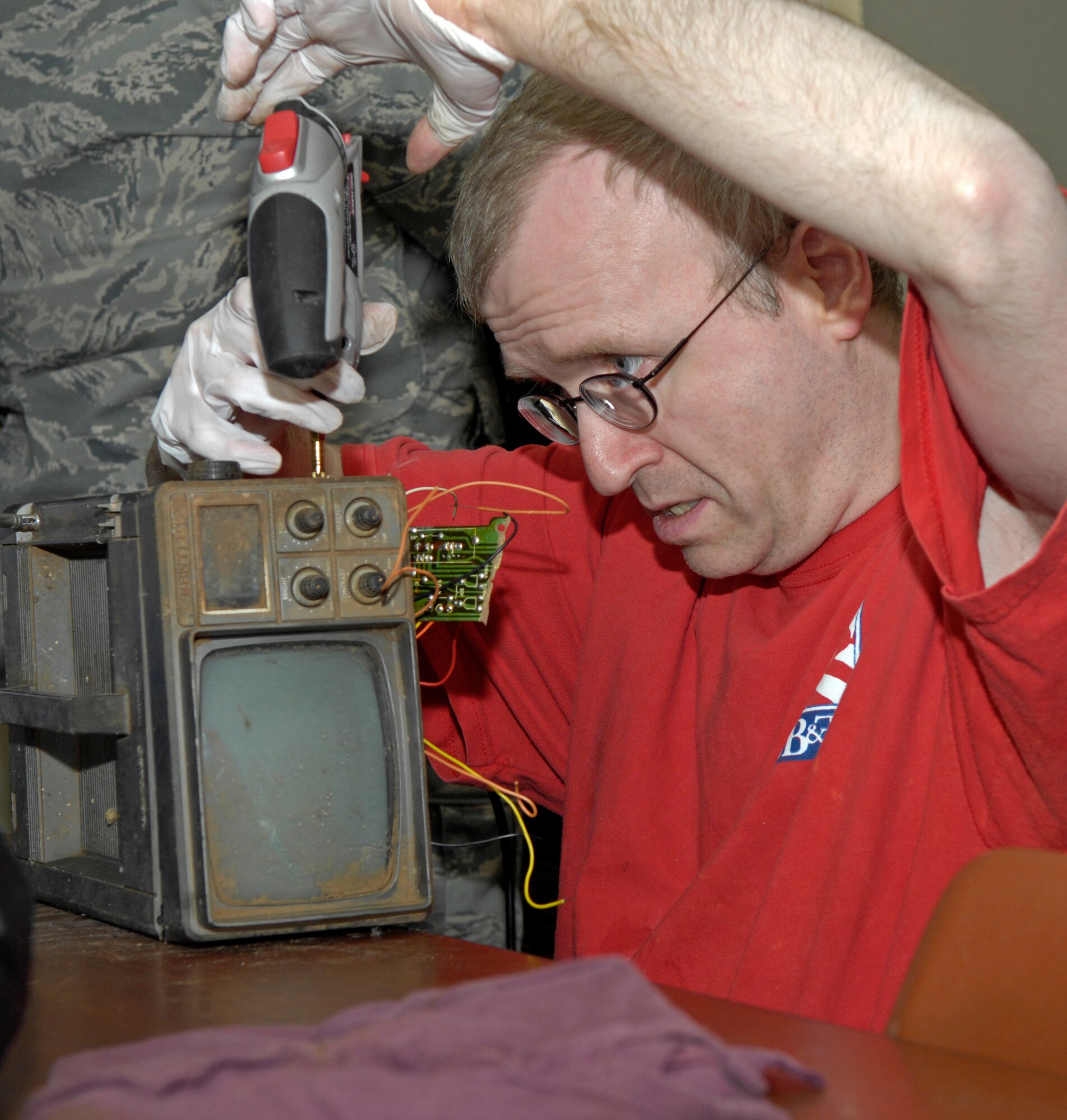 As a client repairs parts on a television radio, he is able to work in a safe environment thanks to the Handicap are Producers house located on the east side of base. (Senior Airman Alexandra M. Sandoval/U.S. Air Force)