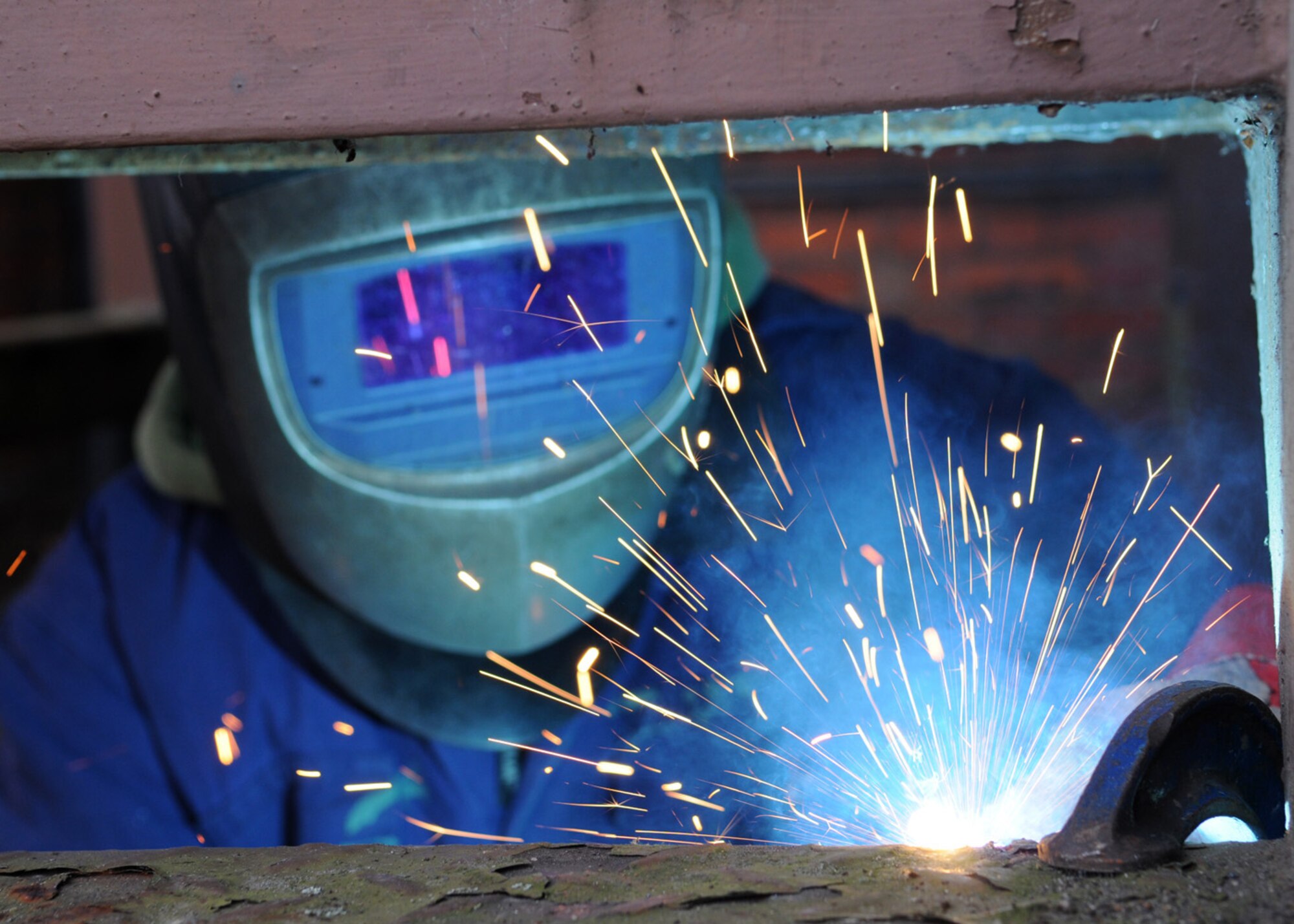 David Whyte, a contractor, welds together steps during a repair process outside building 239 Jan. 30, 2009, at RAF Mildenhall, England. Due to the deteriorating conditions of the staircase, Mr. Whyte performed spot welds to secure the loose steps. (U.S. Air Force photo by Staff Sgt. Jerry Fleshman)