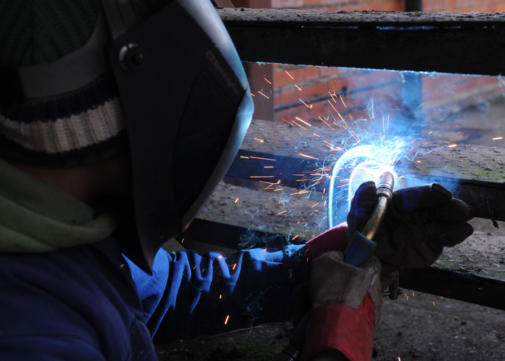 David Whyte, a contractor, welds together steps during a repair process outside building 239 Jan. 30, 2009, at RAF Mildenhall, England. Due to the deteriorating conditions of the staircase, Mr. Whyte performed spot welds to secure the loose steps. (U.S. Air Force photo by Staff Sgt. Jerry Fleshman)