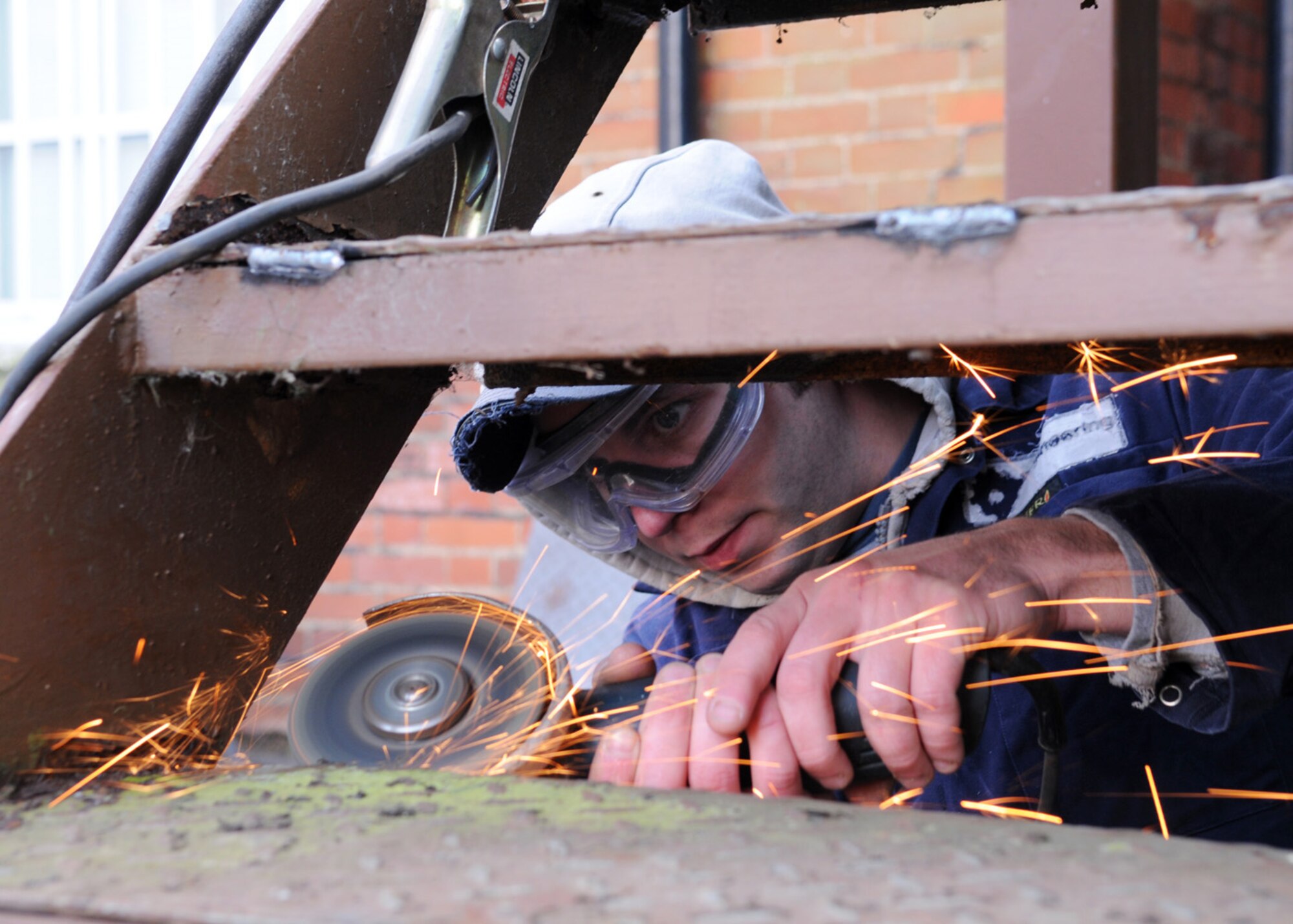 Matt Claydon, a contractor, grinds broken welds prior to repairs made to the stairs on the back side of Building 239 Jan. 30, 2009, at RAF Mildenhall, England. (U.S. Air Force photo by Staff Sgt. Jerry Fleshman)