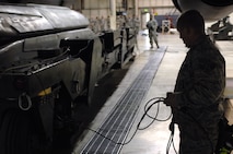 MINOT AIR FORCE BASE, N.D. --  Airman 1st Class Jason McManus, 5th Aircraft Maintenance Squadron weapons load crew member, holds one of the two power control unit dead-man switches from a munitions handling Unit-196/M trailer, as his team puts the machine away after using it to load a B-52H Stratofortress with weapons during an Eighth Air Force inspected load crew competition here Feb. 3. (U.S. Air Force photo by Senior Airman Kelly Timney)