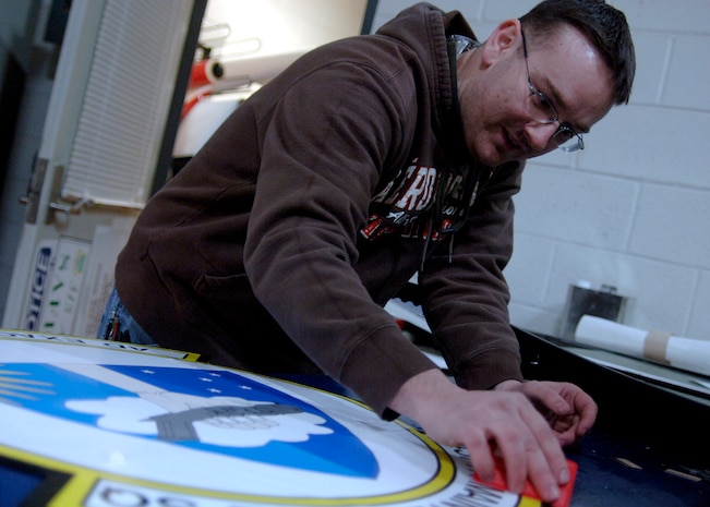 Randall Pearce creates a 437th Maintenance Squadron emblem by hand at the 437th Maintenance Squadron Aircraft Structural Maintenance Shop Feb. 4. The 437 MXS Aircraft Structural Maintenance Shop performs all structural maintenance and corrosion control for all C-17s assigned to the base. Mr. Pearce is with the 315th Maintenance Squadron. (U.S. Air Force photo/Senior Airman Timothy Taylor) 