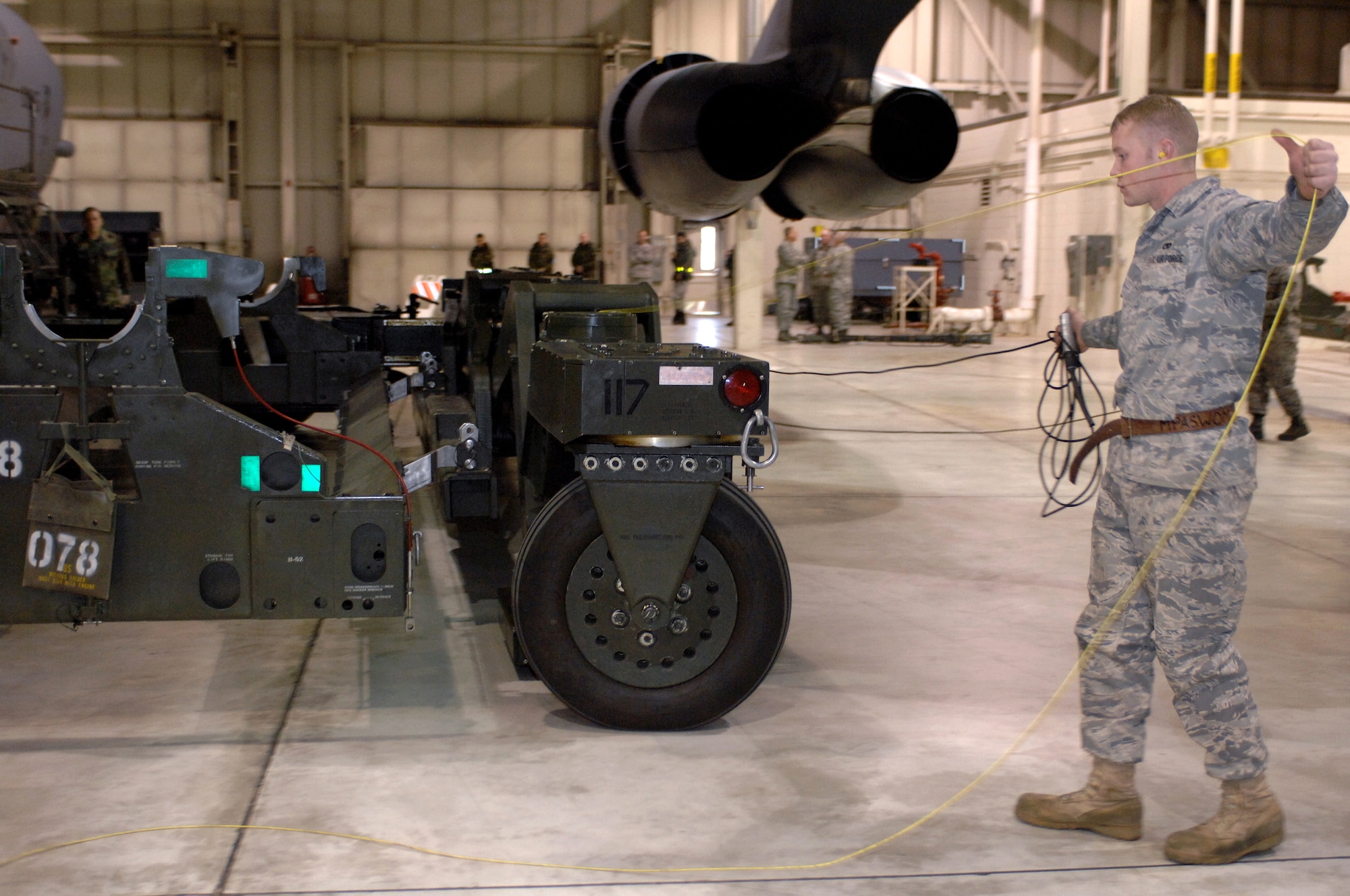 MINOT AIR FORCE BASE, N.D. --  Airman First Class Brady Fender, 5th Aircraft Maintenance Squadron weapons load crew member, expertly manages the power control unit dead-man switch in one hand, while he prevents the grounding wire from getting caught in the Munitions Handling Unit-196/M trailer, as his team approaches the tail end of the load crew competition here Feb. 3. (U.S. Air Force photo by Senior Airman Kelly Timney)