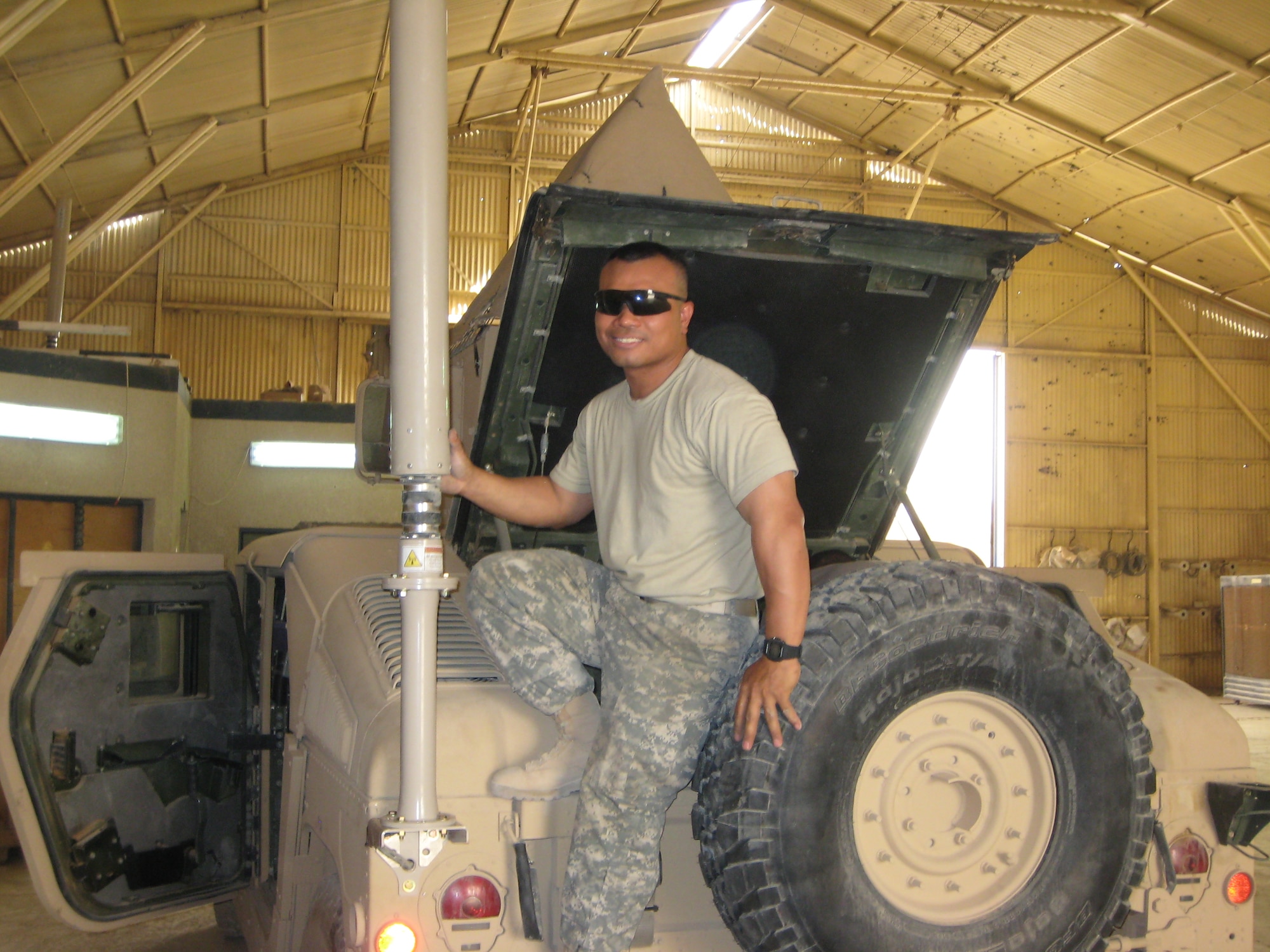 Maj. Joemar Rodrigo, instructor electronic combat officer, 552nd Training Squadron, poses for a picture with the large antenna that is part of the CREW system mounted on a humvee.  Major Rodrigo was deployed for six months to Iraq to serve as the Electronic Warfare Officer for an Army battalion.  Photo courtesy of Major Rodrigo.