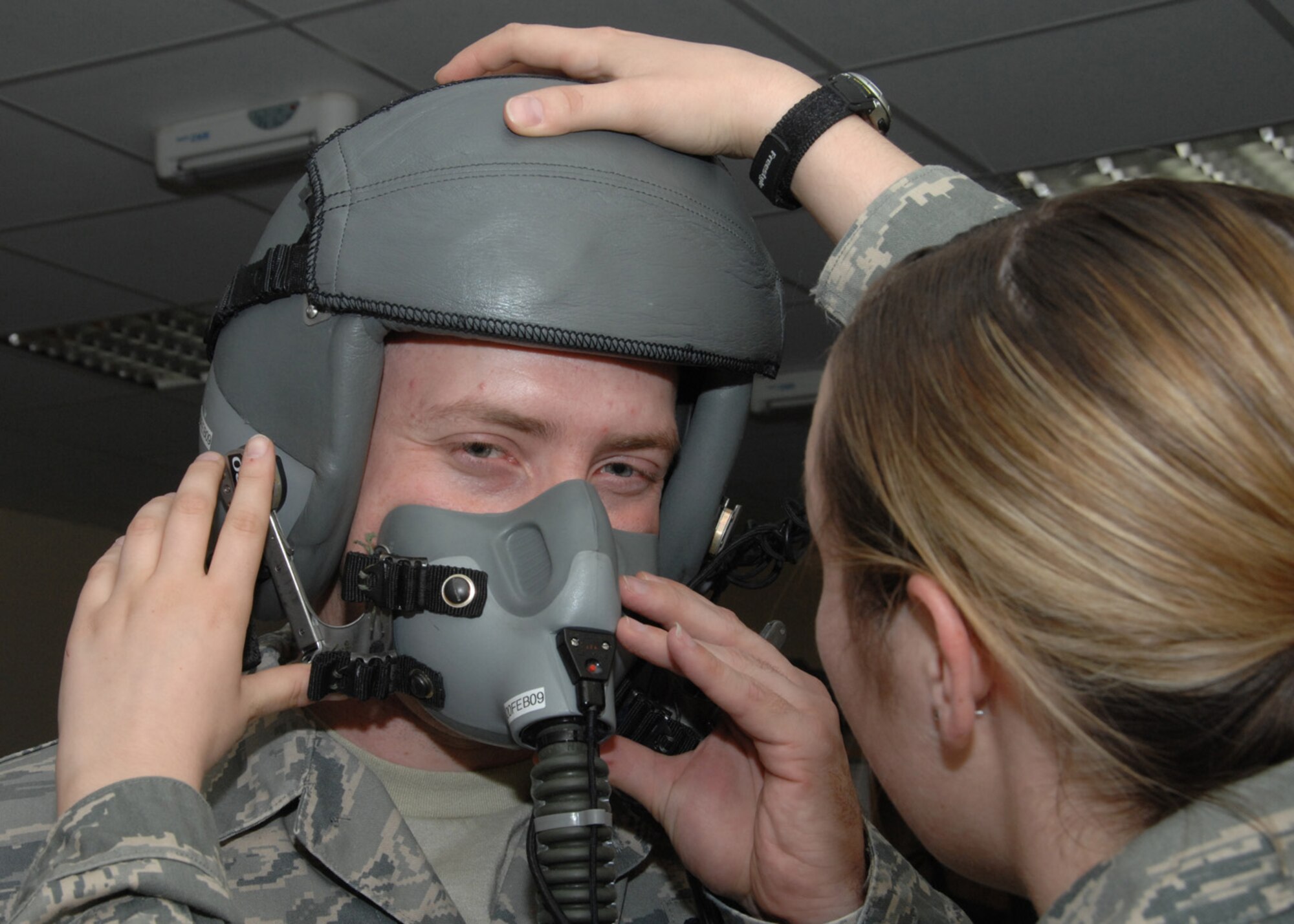 SOUTHWEST ASIA -- Airman 1st Class Kayla Hutton, 43rd Expeditionary Electronic Combat Squadron life support technician, fits a helmet to Staff Sgt. Michael Porter, 43rd Expeditionary Electronic Combat Squadron, before she tests it at an air base in Southwest Asia, Feb. 3. All aircrew members are instructed to complete a helmet and mask check before each flight. (U.S. Air Force photo/Senior Airman Courtney Richardson)