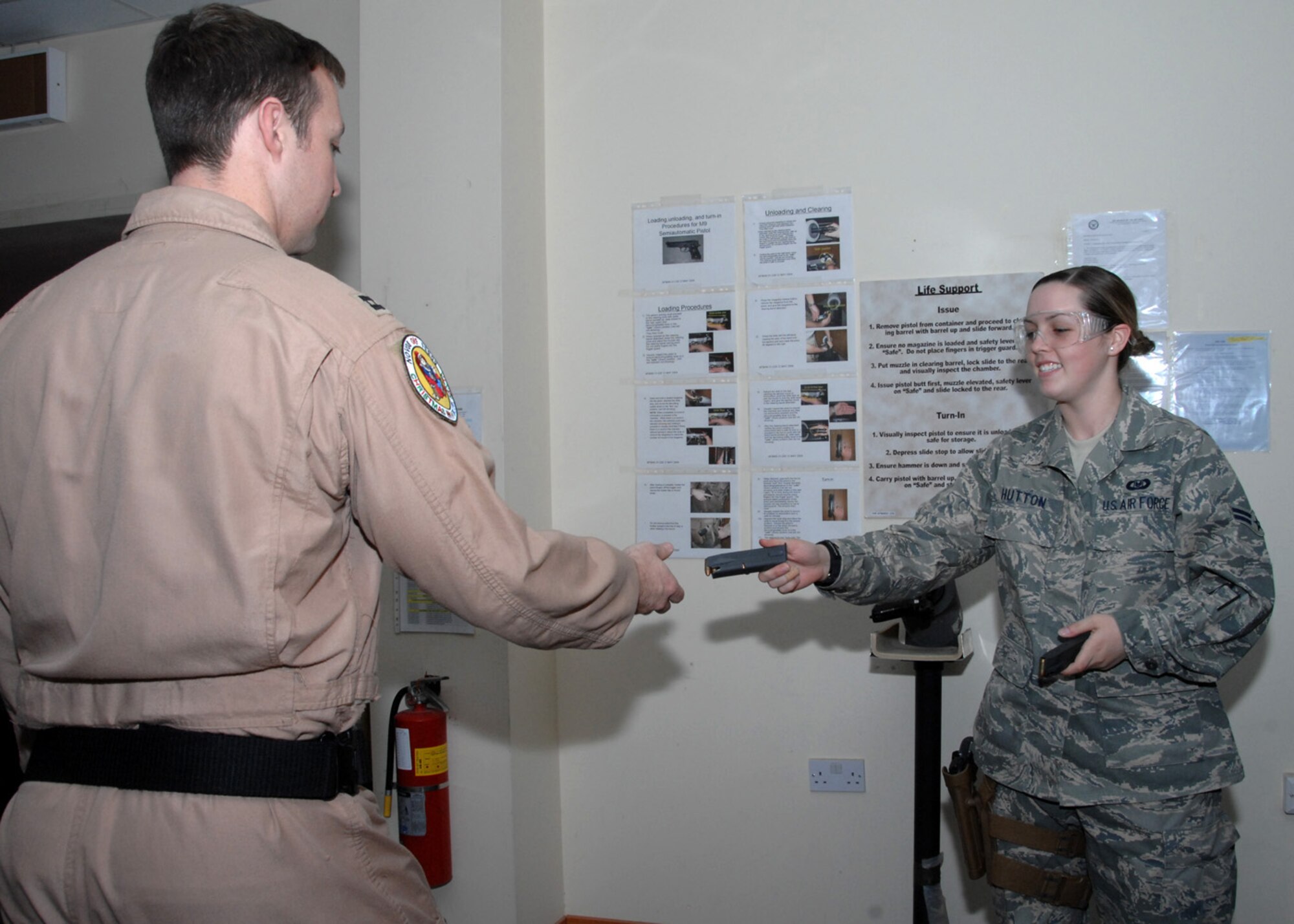 SOUTHWEST ASIA -- Airman 1st Class Kayla Hutton, 43rd Expeditionary Electronic Combat Squadron life support technician, hands an aircrew member a loaded magazine before watching him load it into his weapon at an air base in Southwest Asia, Feb. 3. Every aircrew member must get armed up before their flight in case of an emergency. (U.S. Air Force photo/Senior Airman Courtney Richardson)