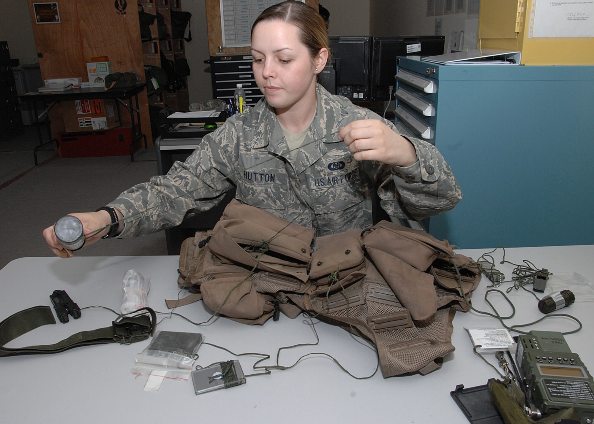 SOUTHWEST ASIA -- Airman 1st Class Kayla Hutton, 43rd Expeditionary Electronic Combat Squadron life support technician, straightens out the string that attaches the smoke and illumination flare to an aircrew survival vest at an air base in Southwest Asia, Feb. 3. The vests have life saving essential items that need to be inspected every 60 days for serviceability. (U.S. Air Force photo/Senior Airman Courtney Richardson)