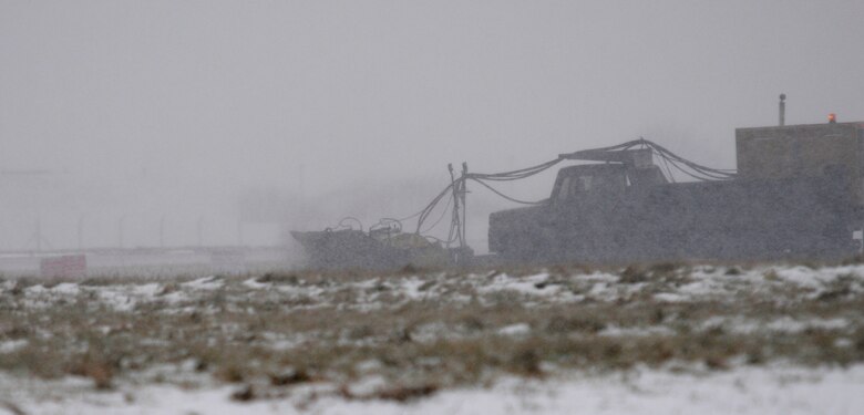 A 100th Civil Engineer Squadron employees uses a truck to clean snow from the runway at RAF Mildenhall, England Feb. 2, 2009. The snow which fell Feb. 2 and 5, 2009, resulted in late reporting for non mission-critical personnel and Department of Defense Dependants School students. (U.S. Air Force photo by Senior Airman Chris Ingersoll)