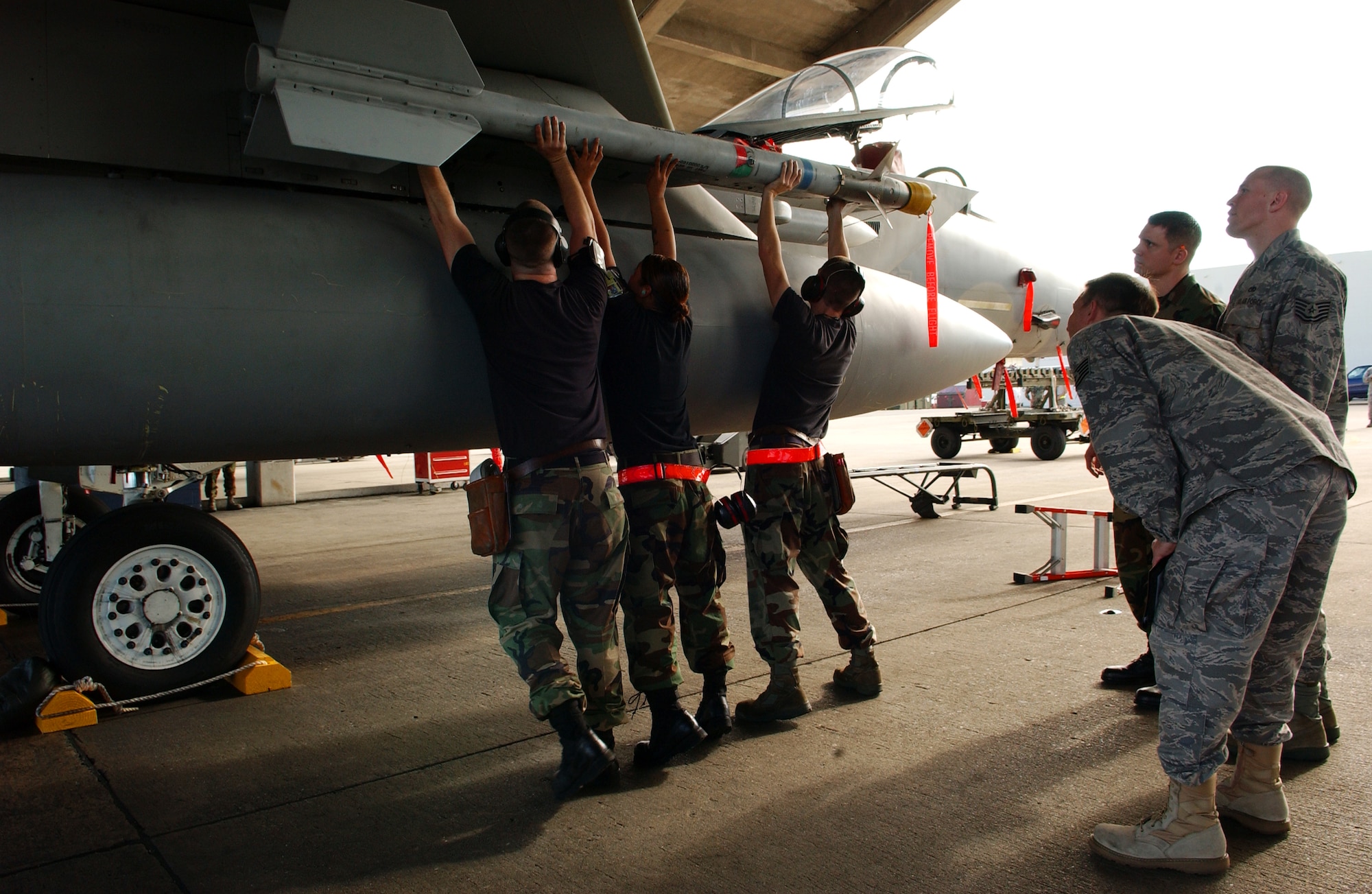A weapons load crew from the 18th Aircraft Maintenance Squadron attaches an AIM-9 missile to an F-15C Eagle during the Turkey Shoot competition Jan. 30 at Kadena Air Base, Japan.   (U.S. Air Force photo/Tech. Sgt. Rey Ramon)
