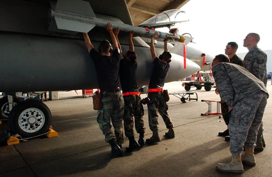 A weapons load crew from the 18th Aircraft Maintenance Squadron attaches an AIM-9 missile to an F-15C Eagle during the Turkey Shoot competition Jan. 30 at Kadena Air Base, Japan.   (U.S. Air Force photo/Tech. Sgt. Rey Ramon)